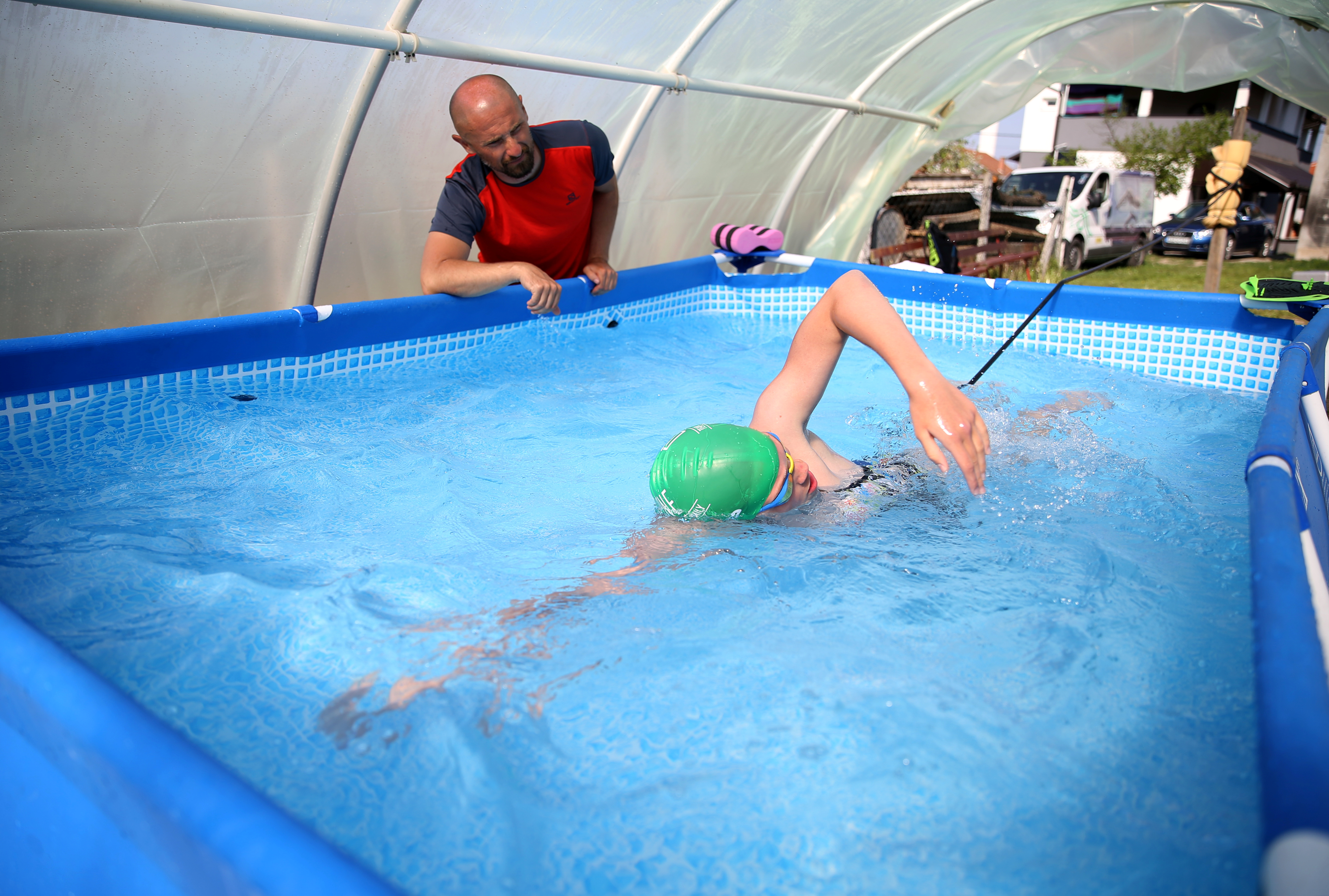 Iman Avdic maintains her form by practicing in a small plastic pool inside an improvised greenhouse in her grandfather's orchard in Doboj