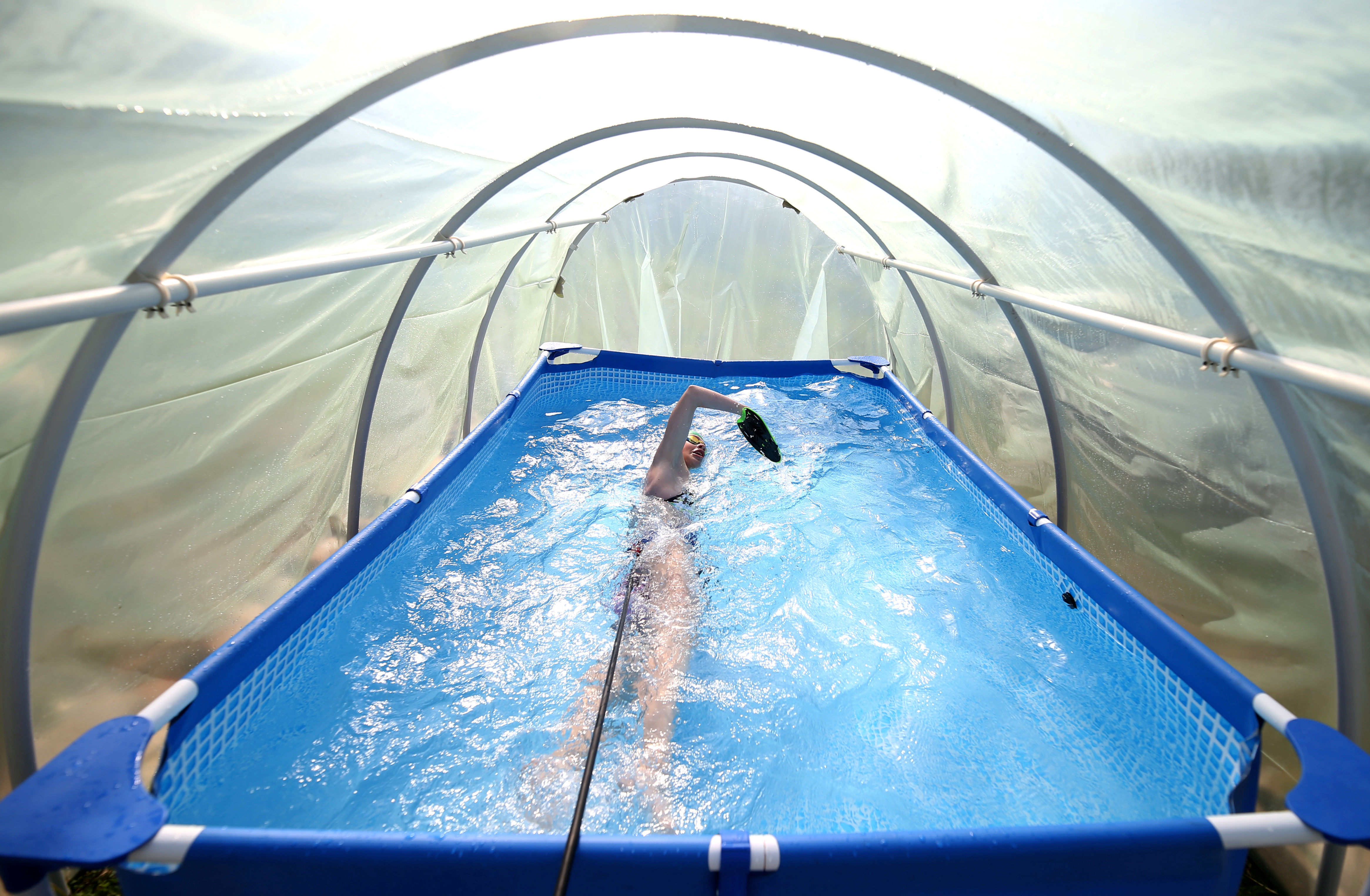Iman Avdic maintains her form by practicing in a small plastic pool inside an improvised greenhouse in her grandfather's orchard in Doboj