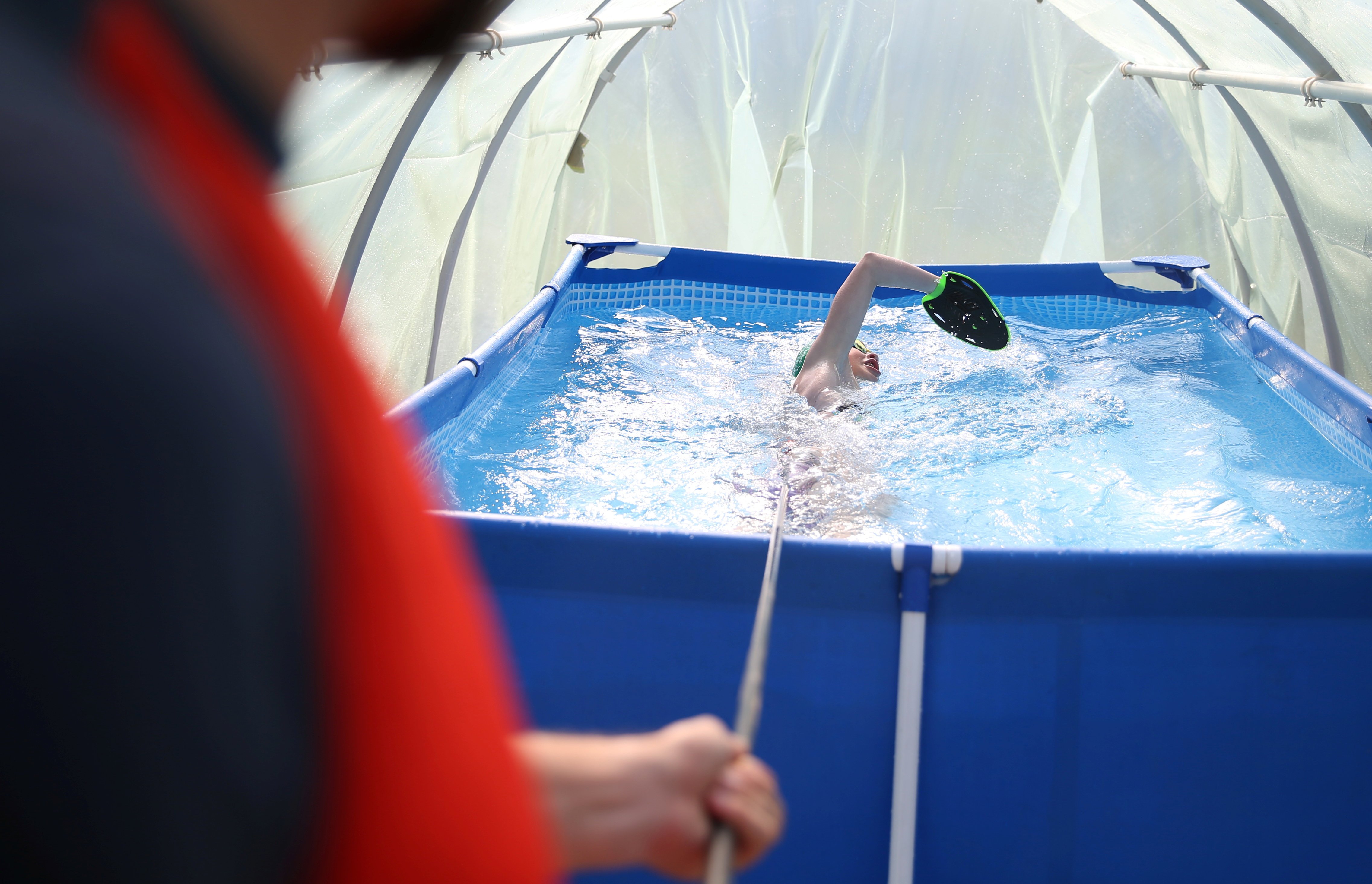 Iman Avdic maintains her form by practicing in a small plastic pool inside an improvised greenhouse in her grandfather's orchard in Doboj