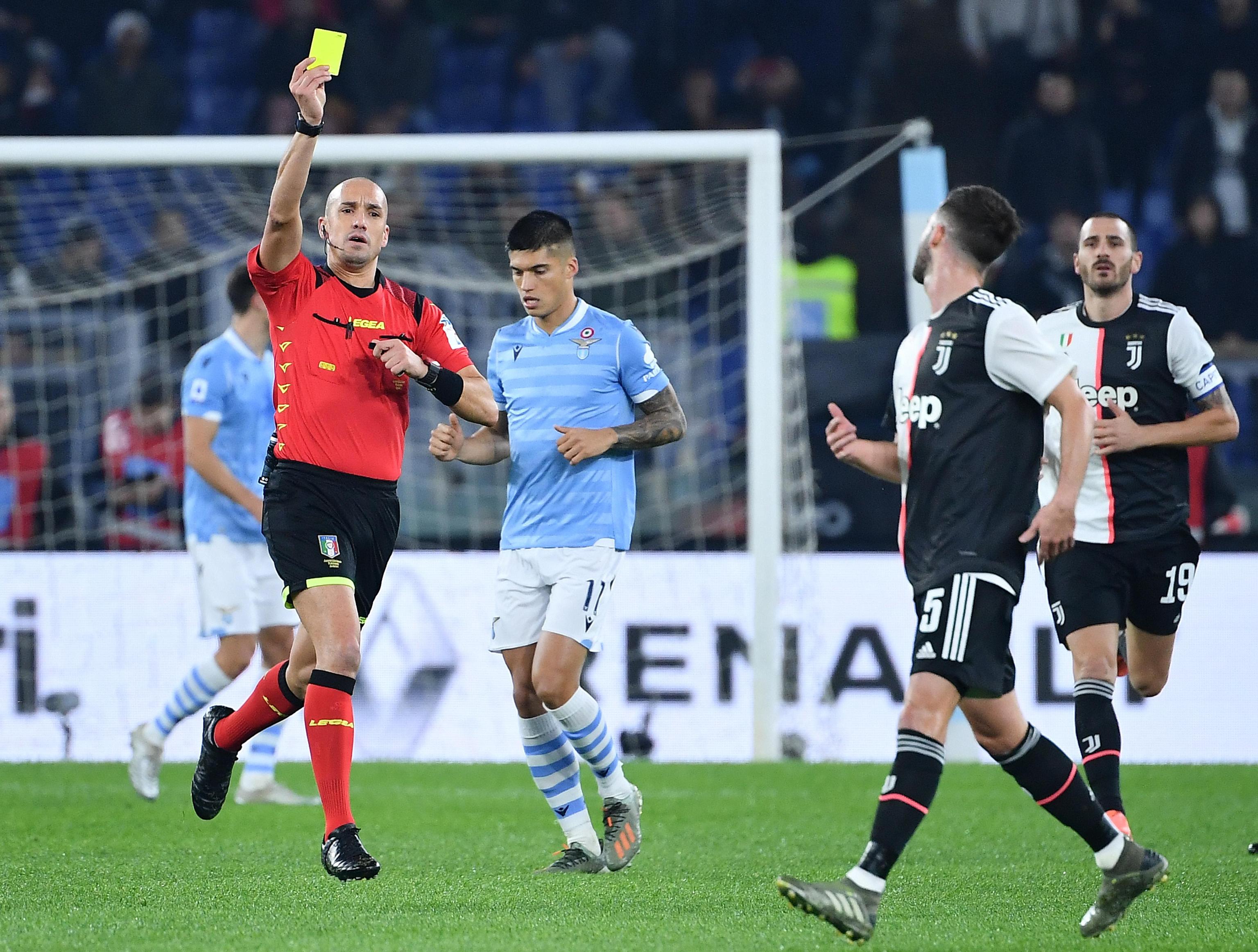 epa08053120 Referee Michael Fabbri (L) shows a yellow card to FC Juventus' Miralem Pjanic during the Italian Serie A soccer match between SS Lazio and FC Juventus at the Olimpico stadium in Rome, Italy, 07 December 2019.  EPA-EFE/ETTORE FERRARI