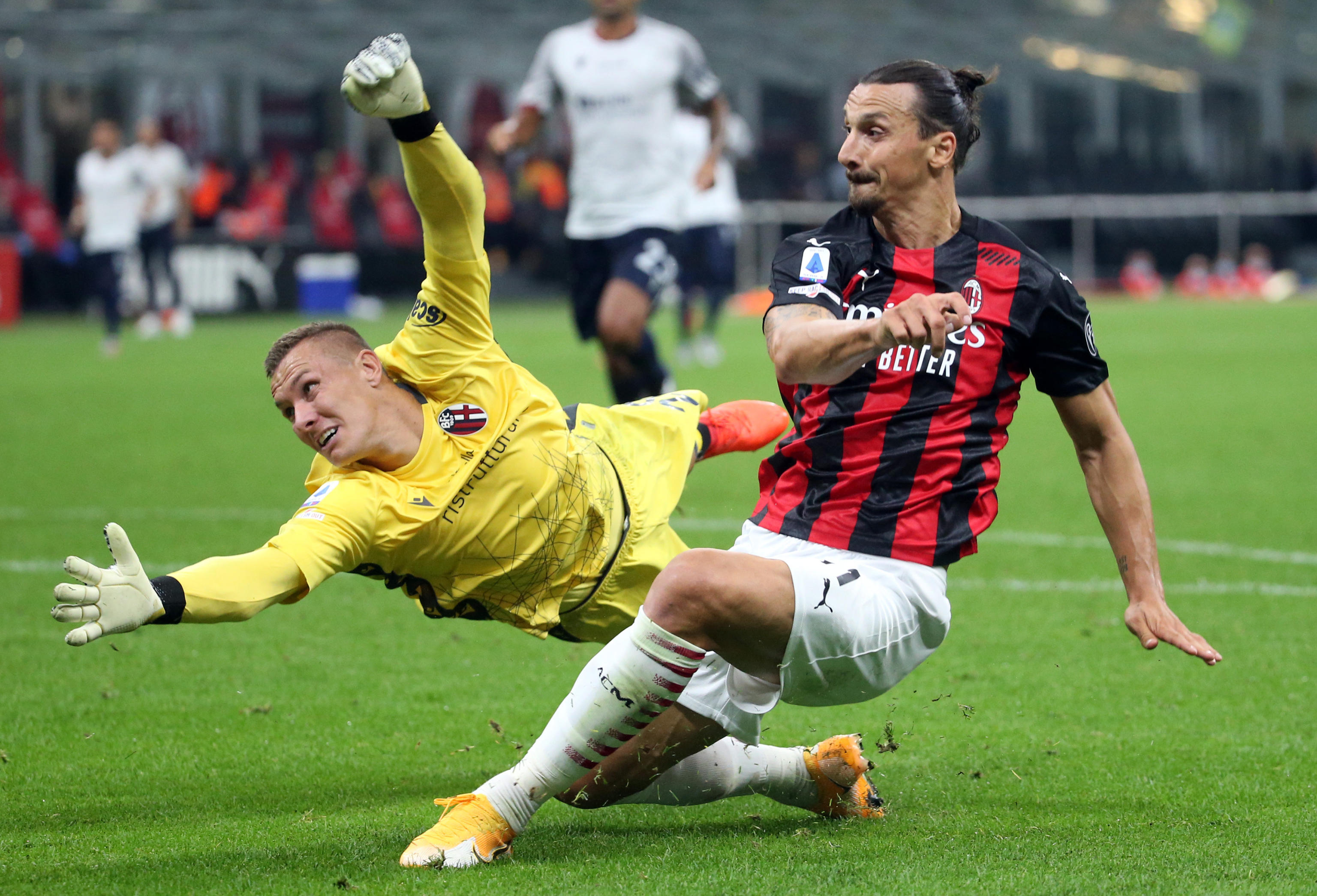 epa08687213 AC Milan's Zlatan Ibrahimovic (R) challenges for the ball Bologna's goalkeeper Lukas Skorupski during the Italian Serie A soccer match Ac Milan vs Fc Bologna at Giuseppe Meazza stadium in Milan, Italy, 21 September  2020.  EPA-EFE/MATTEO BAZZI