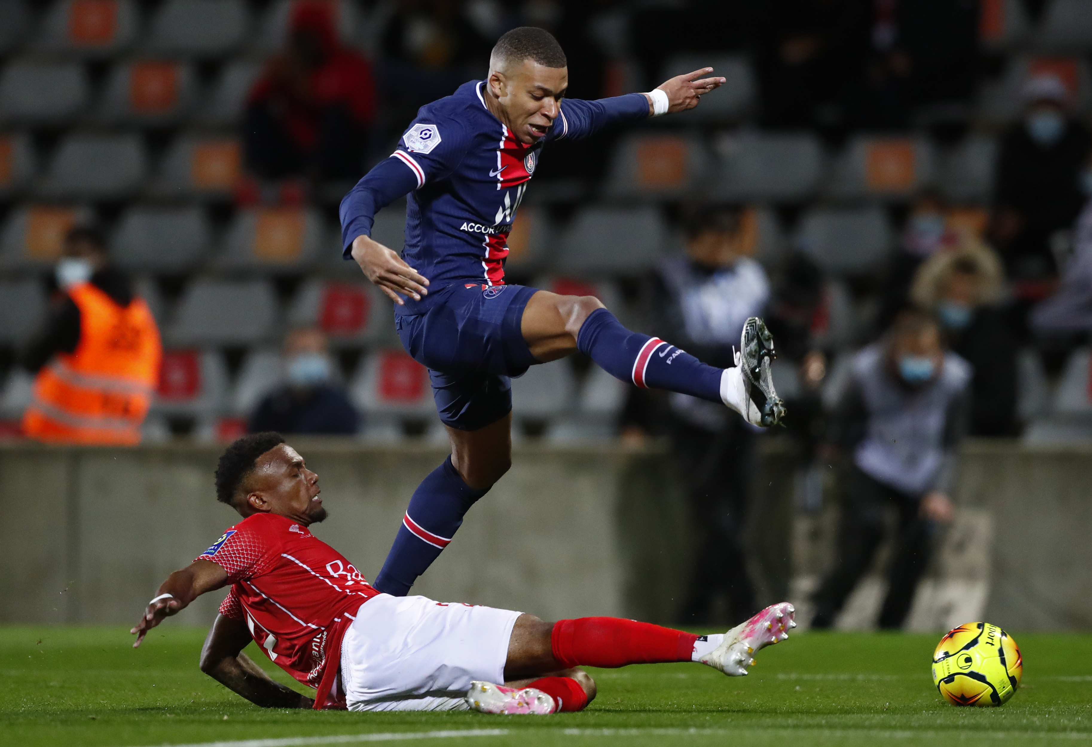 epa08751570 Kylian Mbappe (R) of Paris Saint-Germain and Patrick Burner (L) of Nimes in action during the soccer Ligue 1 match between Nimes Olympique and Paris Saint Germain in Nimes, France, 16 October 2020.  EPA-EFE/Guillaume Horcajuelo