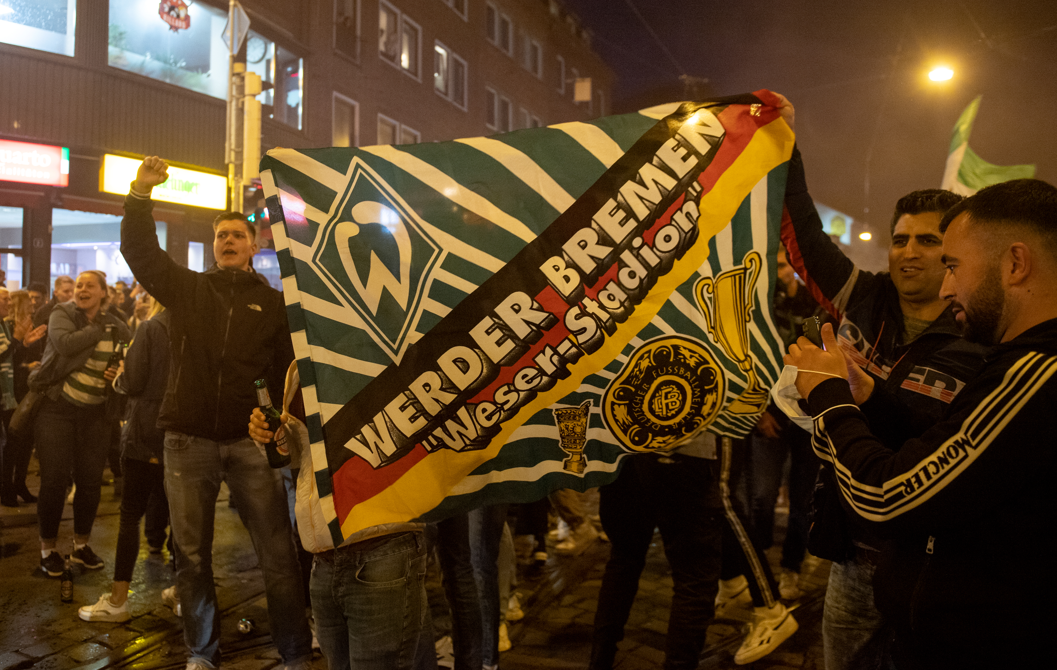 epa08531443 Supporters of Werder Bremen celebrate their win against 1. FC Heidenheim in a German Bundesliga relegation playoff, second leg soccer match, Bremen, Germany, 06 July 2020.  EPA-EFE/DAVID HECKER
