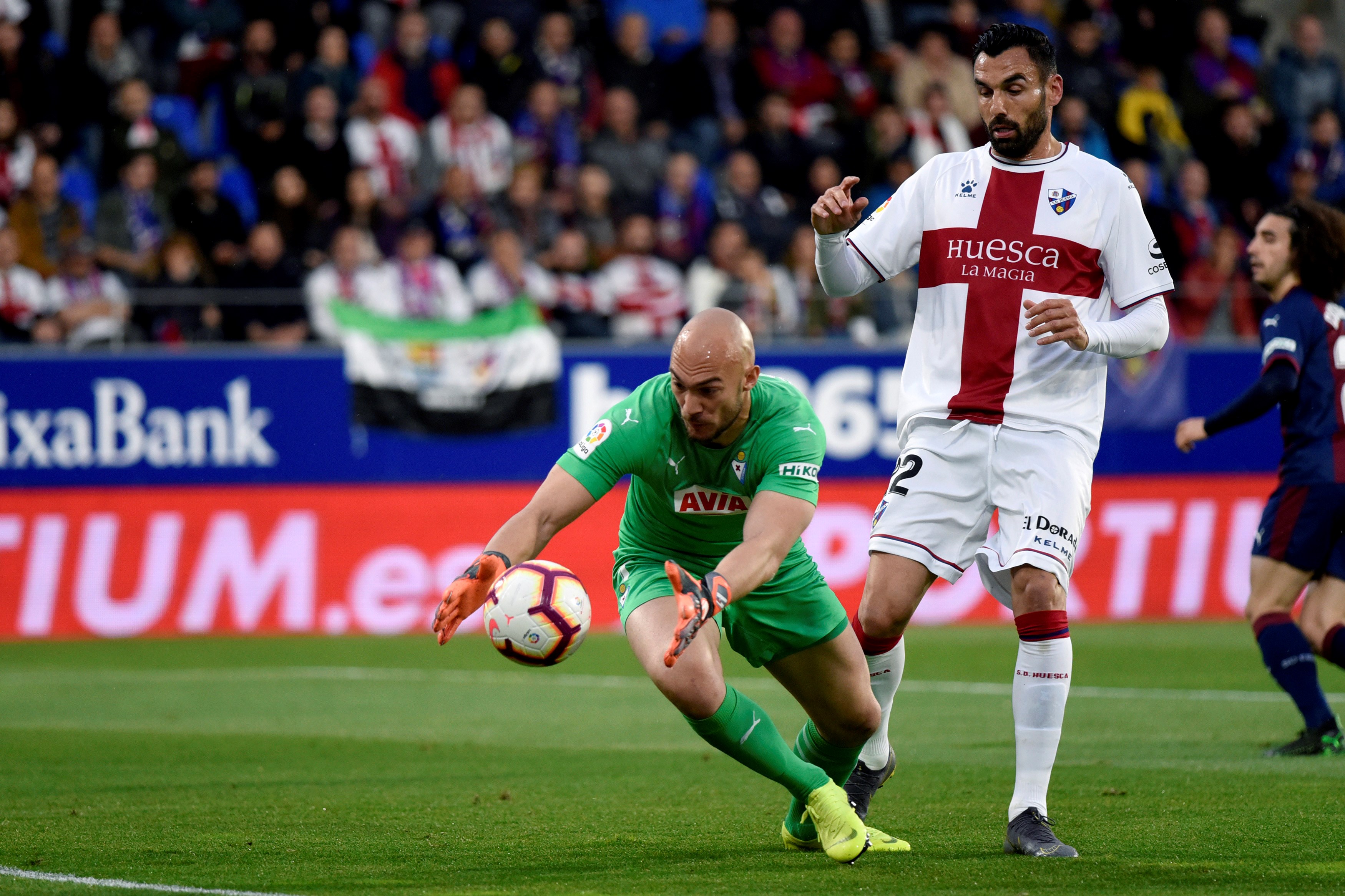 epa07523817 Eibar's goalkeeper Marko Dmitrovic (L) in action against Huesca's forward Enric Gallego (R) during the Spanish LaLiga match between SD Eibar and SD Huesca at  El Alcoraz Stadium in Huesca, Spain, 23 April 2019.  EPA-EFE/JAVIER BLASCO