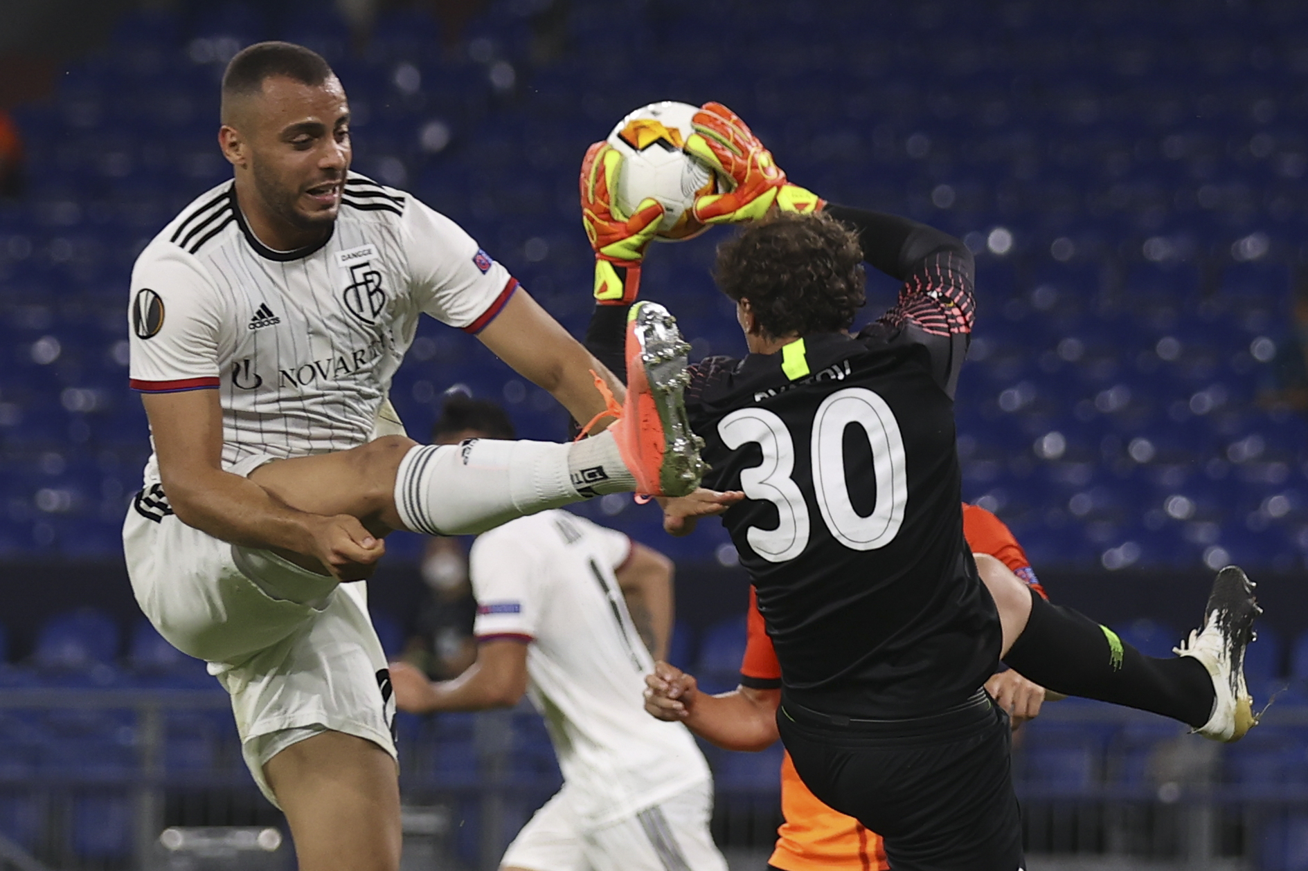 epa08598048 Arthur of Basel (L) in action against goalkeeper Andriy Pyatov of Shakhtar (R) during the UEFA Europa League quarter final match between Shakhtar Donetsk and FC Basel in Gelsenkirchen, Germany, 11 August 2020.  EPA-EFE/Lars Baron / POOL