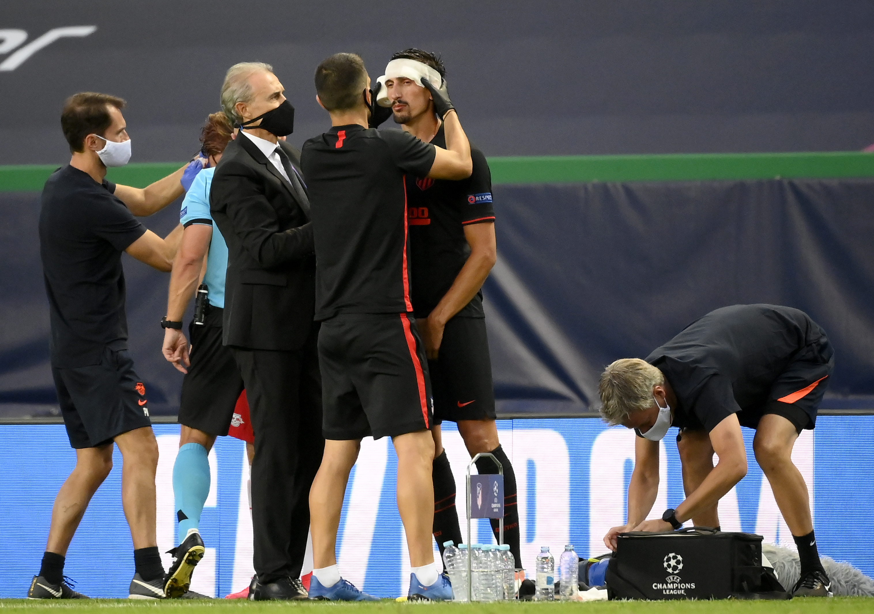epa08601799 Stefan Savic (C) of Atletico receives medical treatment during the UEFA Champions League quarter final match between RB Leipzig and Atletico Madrid in Lisbon, Portugal, 13 August 2020.  EPA-EFE/Lluis Gene / POOL