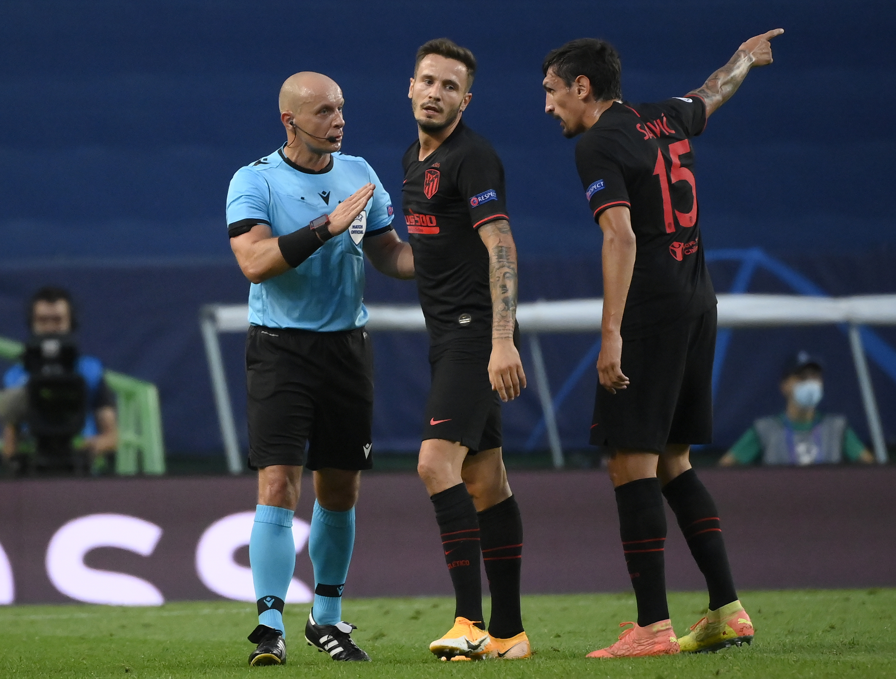 epa08601780 Polish referee Szymon Marciniak  (L) argues with Stefan Savic (R) of Atletico during the UEFA Champions League quarter final match between RB Leipzig and Atletico Madrid in Lisbon, Portugal, 13 August 2020.  EPA-EFE/Lluis Gene / POOL