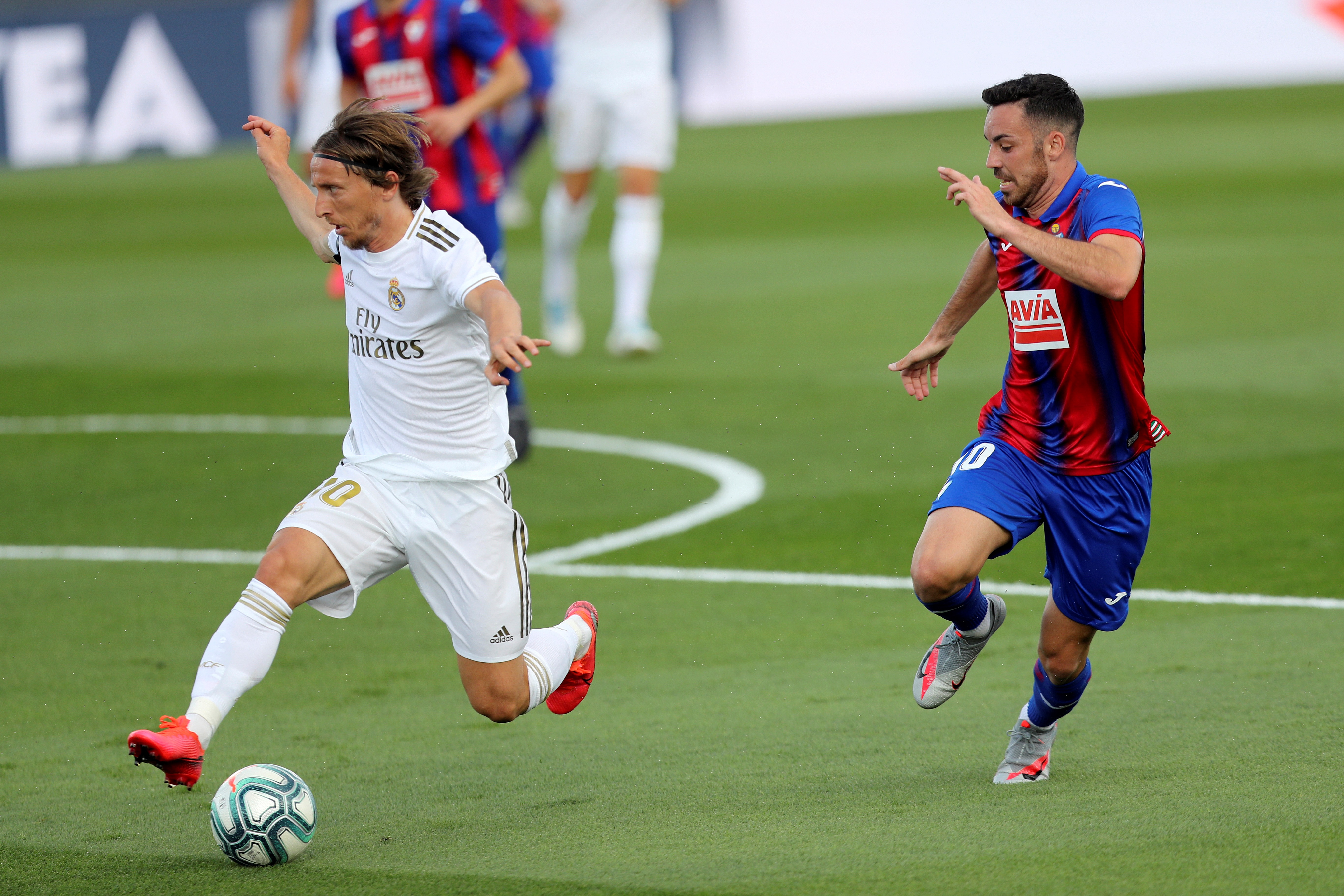 epa08485499 Real Madrid's Luka Modric (L) in action against SD Eibar's Edu Exposito during the Spanish LaLiga soccer match between Real Madrid and SD Eibar behind closed doors at Di Stefano stadium in Madrid, Spain, 14 June 2020.  EPA-EFE/Kiko Huesca
