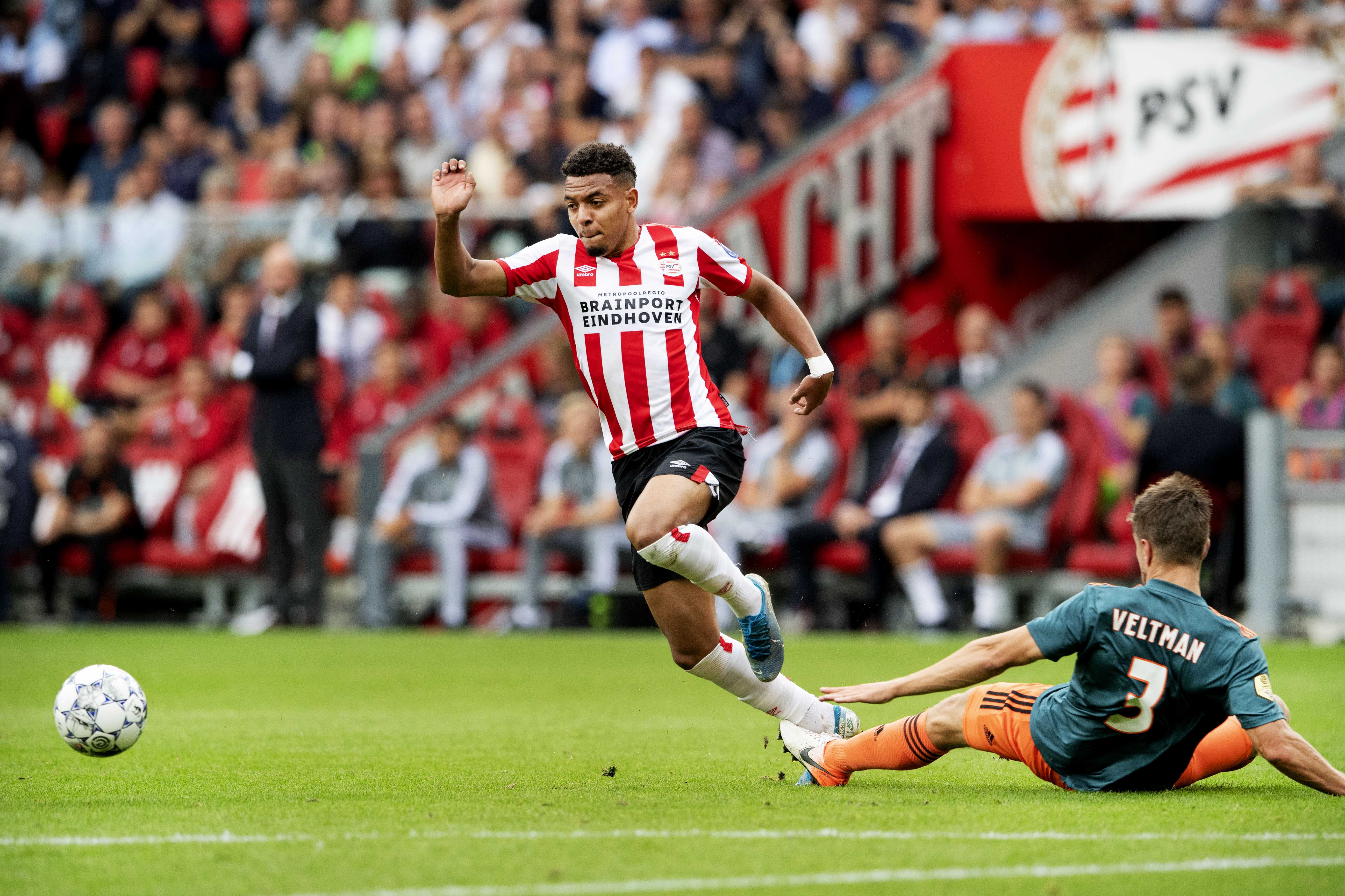 epa07862100 Donyell Malen (L) of PSV in duel with Joel Veltman of Ajax during the Dutch Eredivisie soccer match PSV vs Ajax in Eindhoven, Netherlands 22 September 2019.  EPA-EFE/OLAF KRAAK