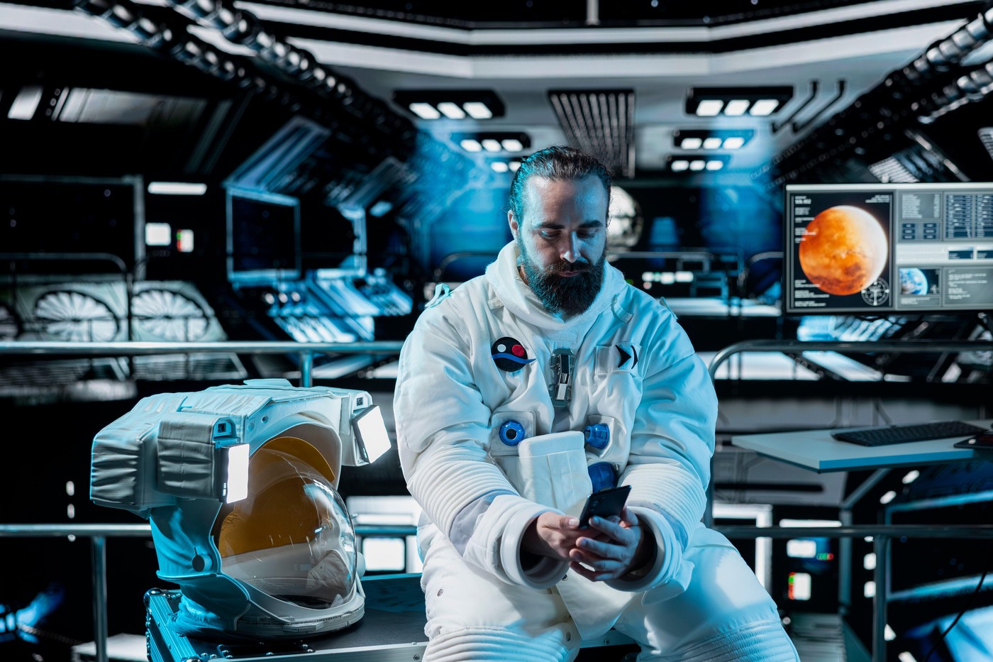 Lonely astronaut using smartphone to text friends before landing spaceship on Mars. Isolated man using phone to chat with family during mission to red planet surface in deep space