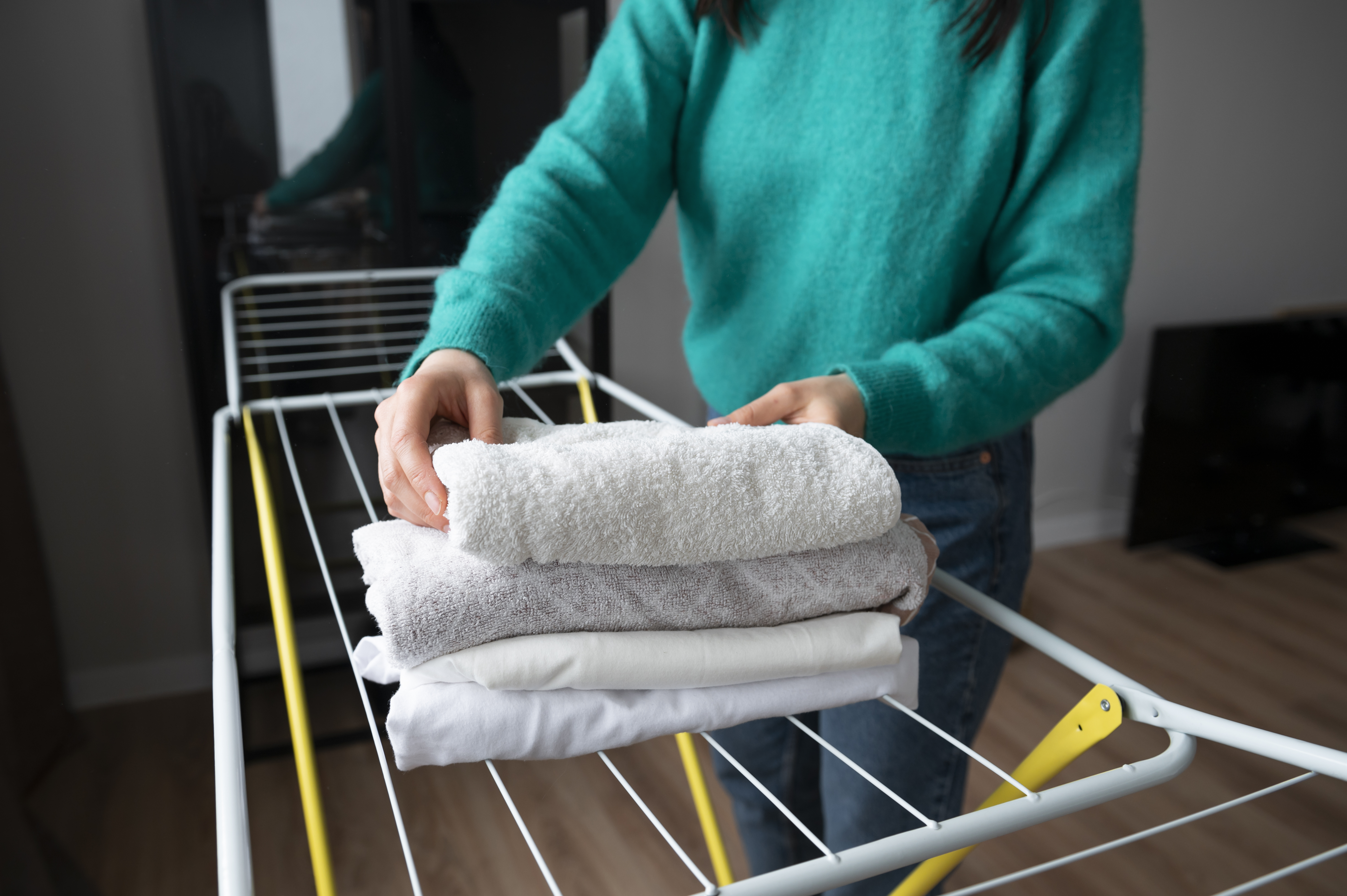 woman-folding-towels-home-quarantine