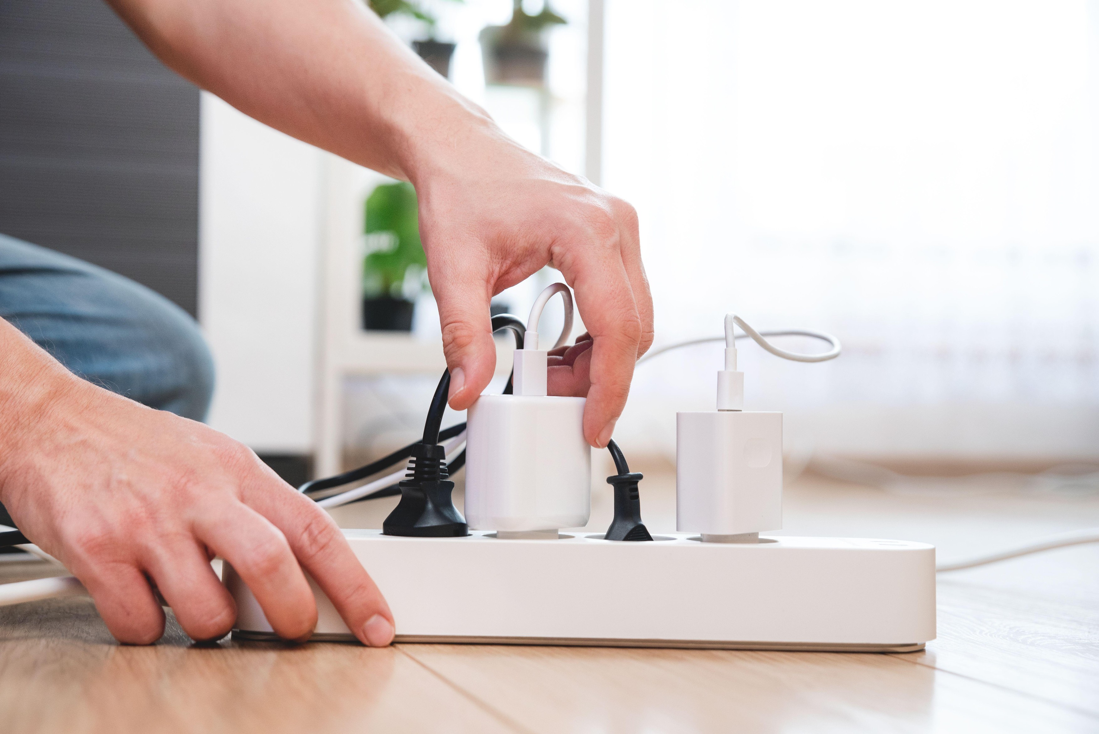Man plugging the power plug. Electrical plug in outlet socket at home.