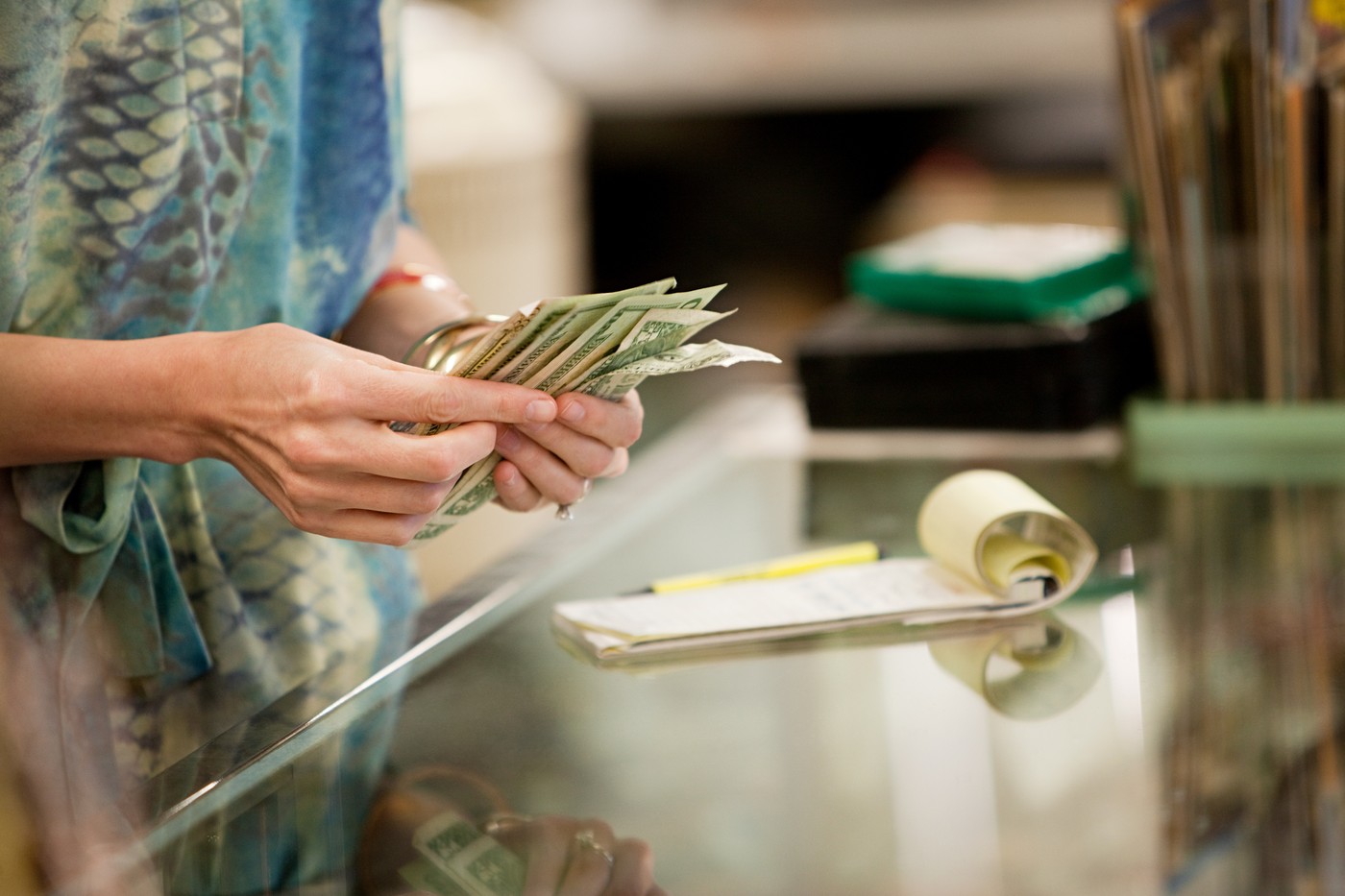 Shop keeper counting money in shop