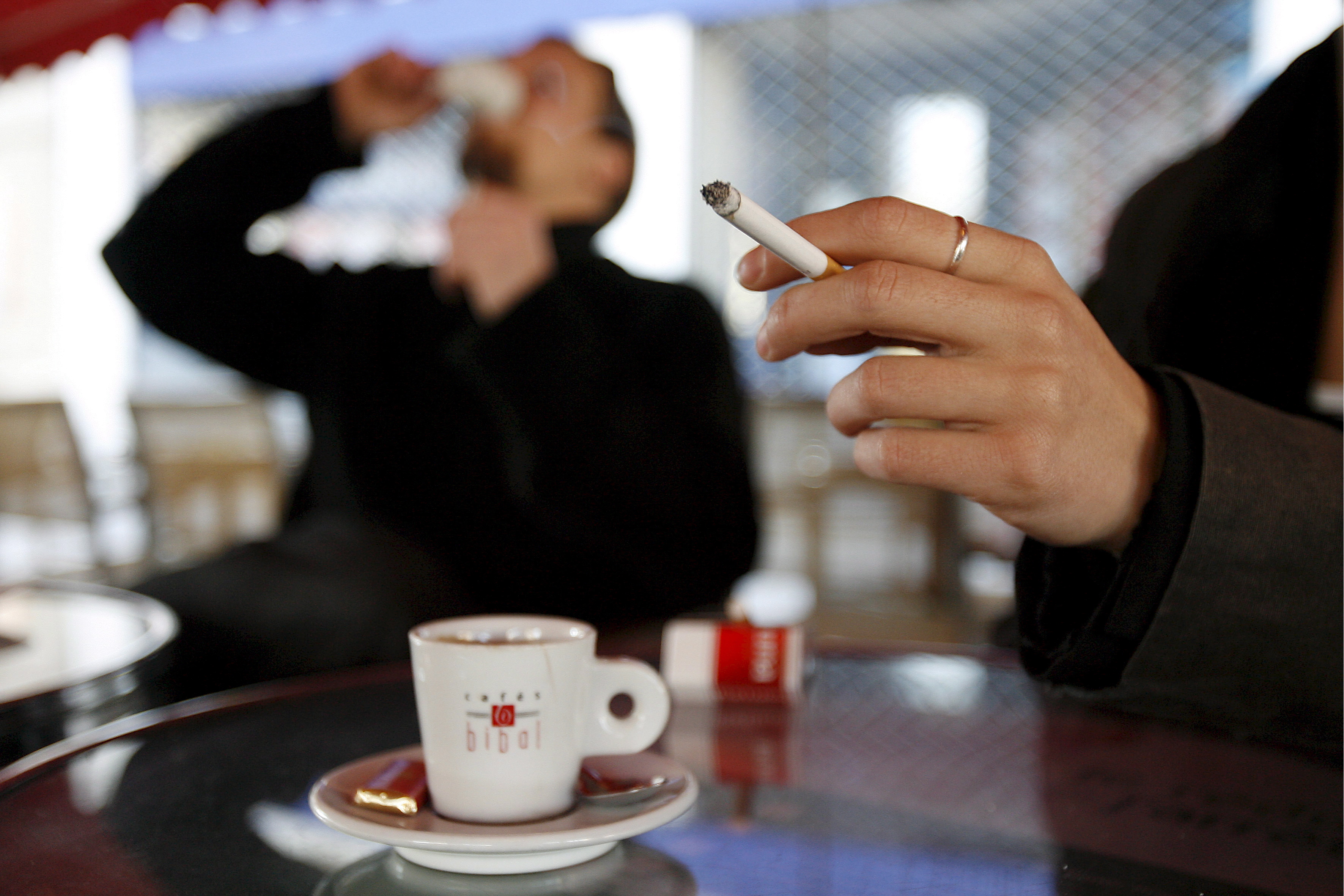 epa01211864 A woman smokes a cigarette outside a restaurant in Montpellier, France, 01 January 2008. France enforces a smoking ban in public places starting 01 January 2008.  EPA/GUILLAUME HORCAJUELO