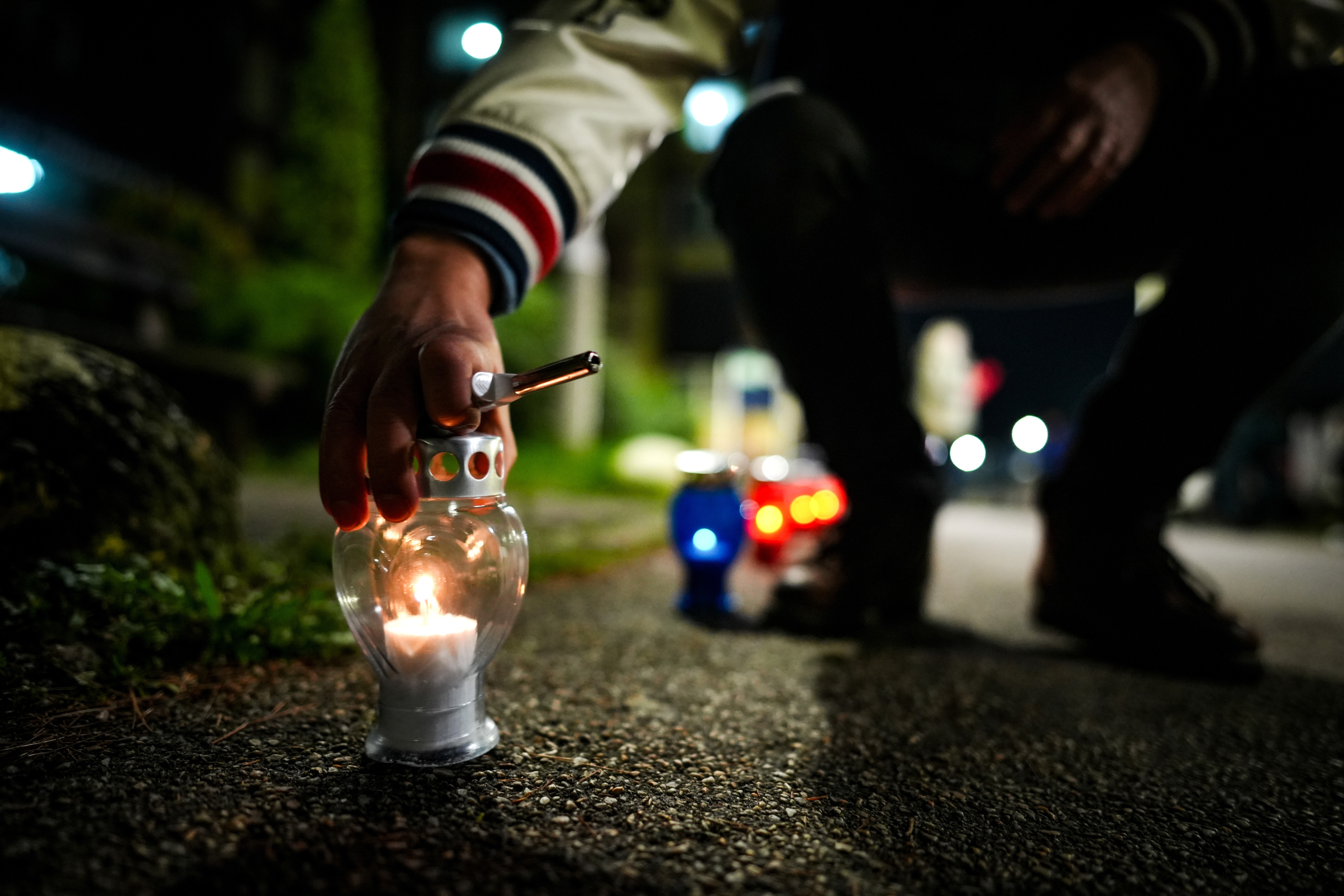 epa12506058 A man lights a candle for the victims of the 'Dom Penzionera' nursing home in Tuzla, Bosnia and Herzegovina, 05 November 2025. At least 11 people died in a nursing home after a fire broke out late on 04 November 2025.  EPA/NIDAL SALJIC