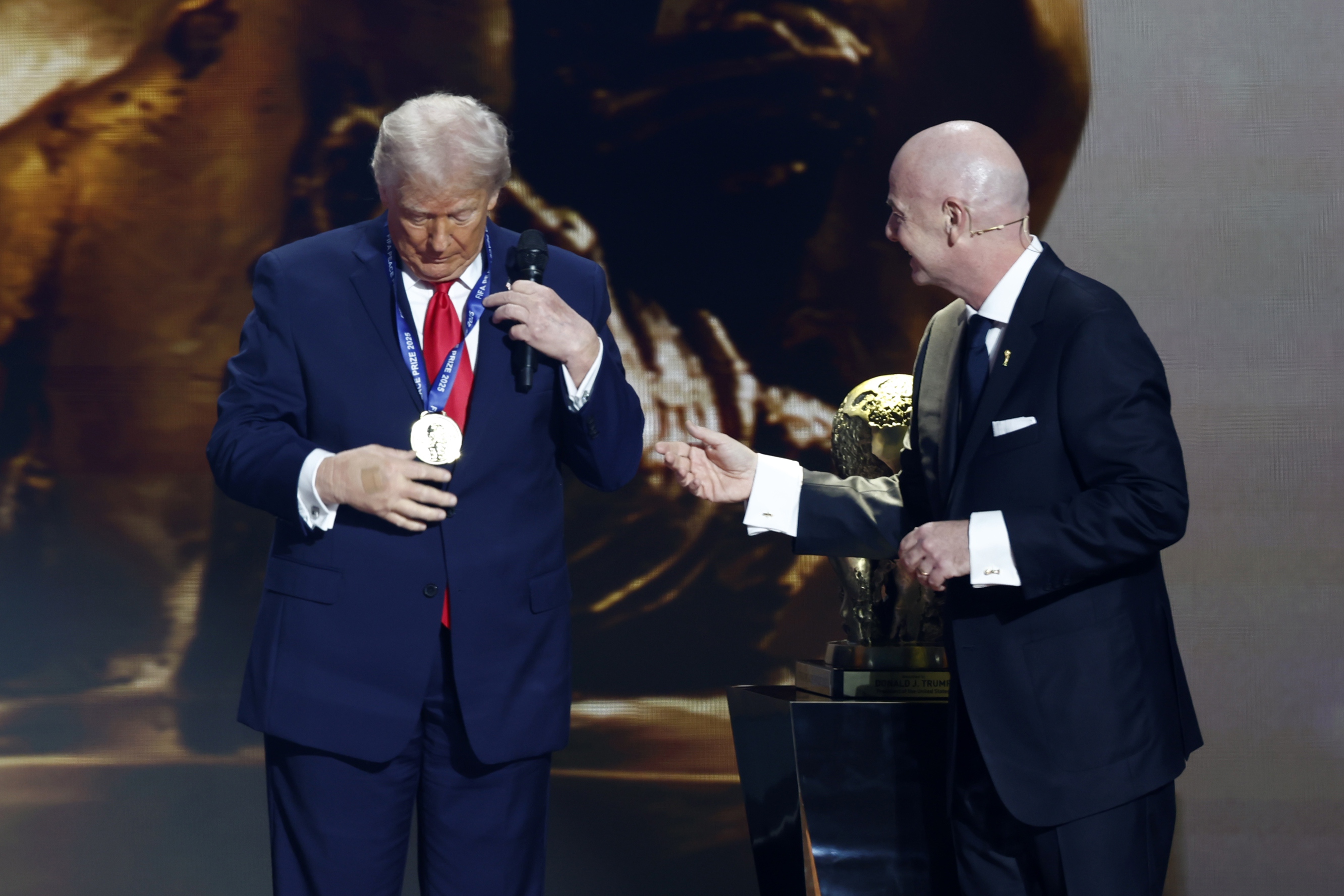 epa12578388 US President Donald Trump (L) receives the FIFA Peace Prize from FIFA President Gianni Infantino during the FIFA World Cup 2026 Final Draw at the Kennedy Center in Washington DC, USA, 05 December 2025.  EPA/WILL OLIVER