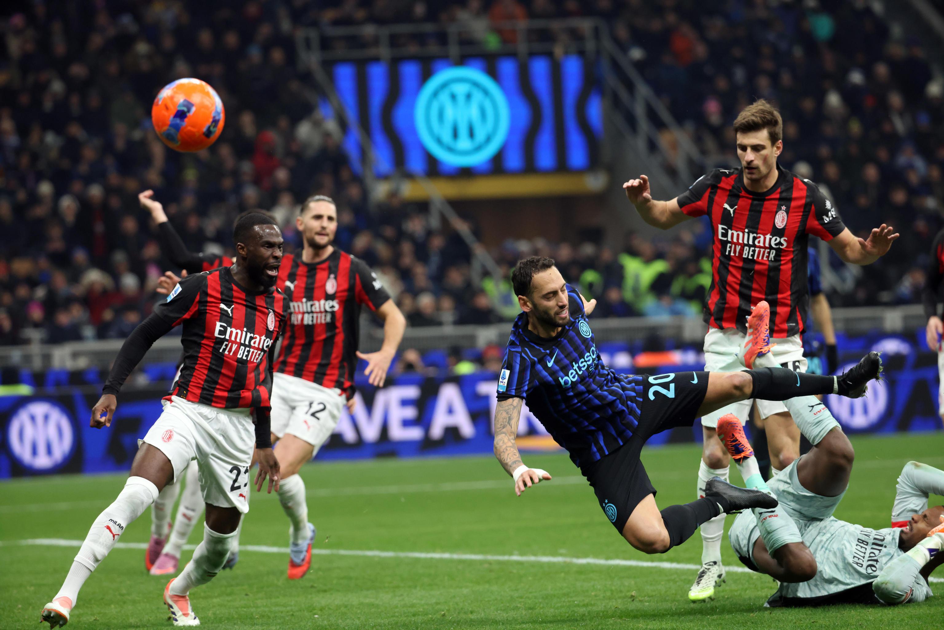 epa12544874 Inter Milans Hakan Calhanoglu (C) in action against AC Milans goalkeeper Mike Maignan (R) during the Italian Serie A soccer match between Inter and Milan at Giuseppe Meazza stadium in Milan, Italy, 23 November 2025.  EPA/MATTEO BAZZI