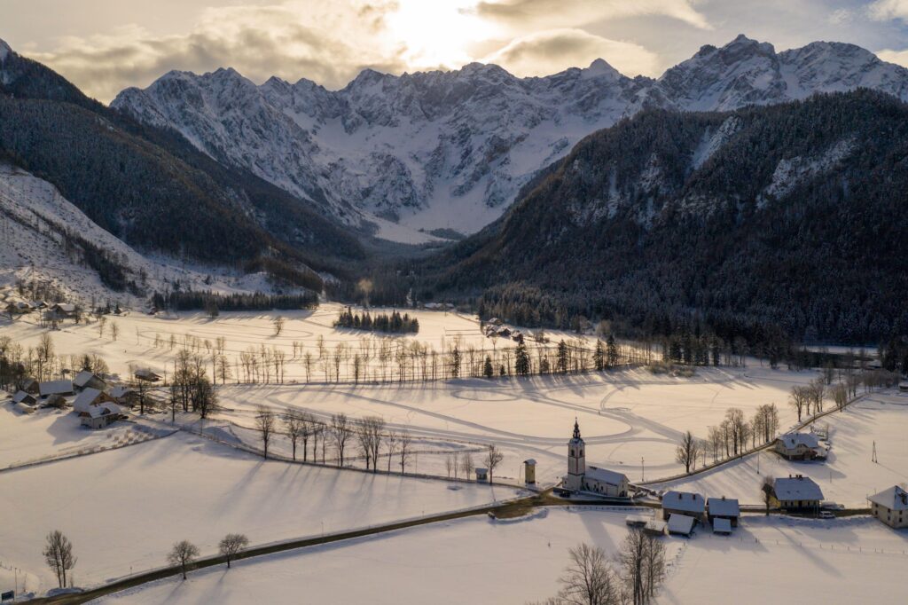 Aerial winter landscape with mountain village and forest covered in snow. Zgornje Jezersko, Slovenia.,Image: 965879414, License: Royalty-free, Restrictions: , Model Release: no, Credit line: 24K-Production / Alamy / Profimedia