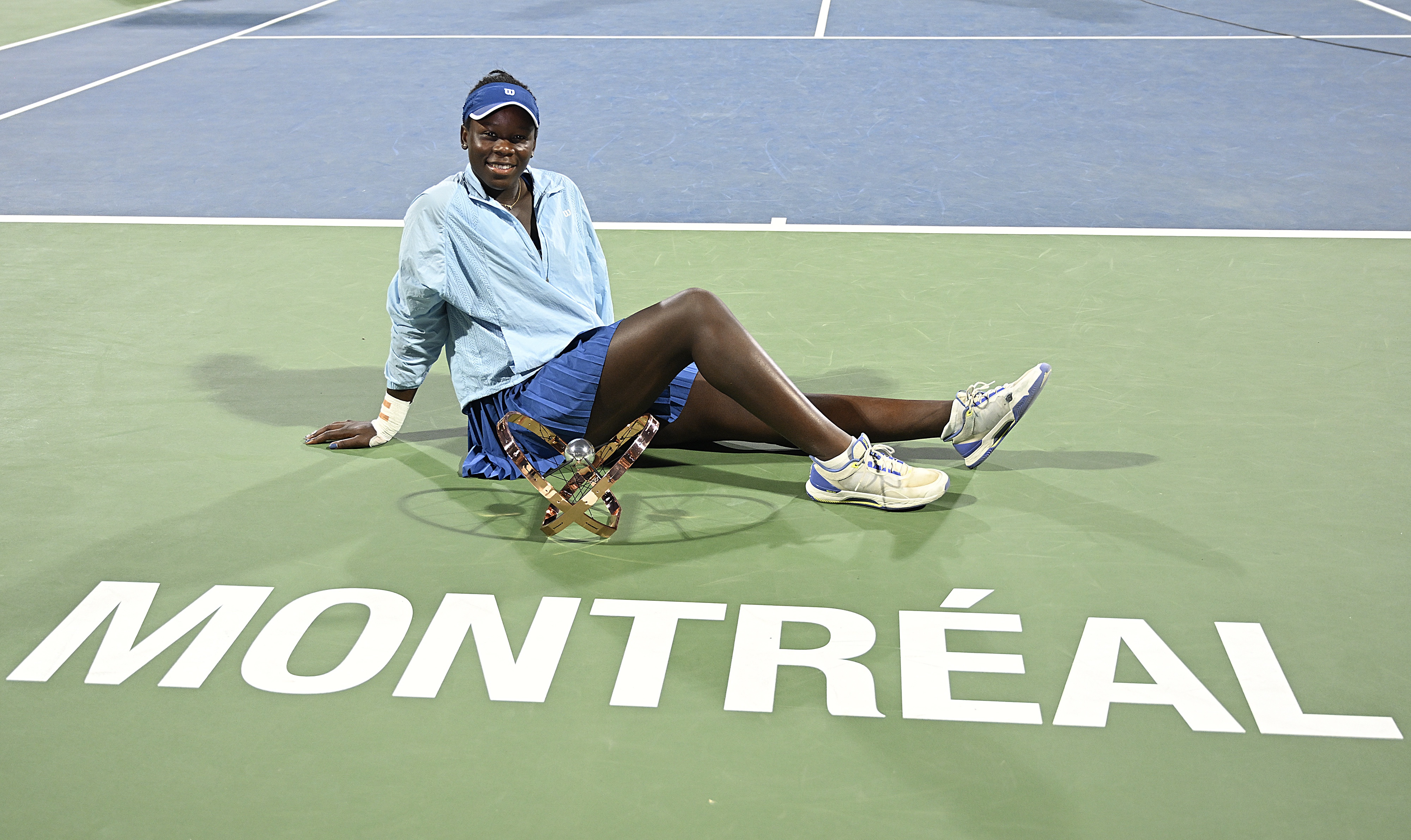 epa12289149 Victoria Mboko of Canada poses with the trophy following her victory over Naomi Osaka of Japan during the final of the National Bank Open at IGA Stadium in Montreal, Canada, 07 August 2025.  EPA/GRAHAM HIUGHES