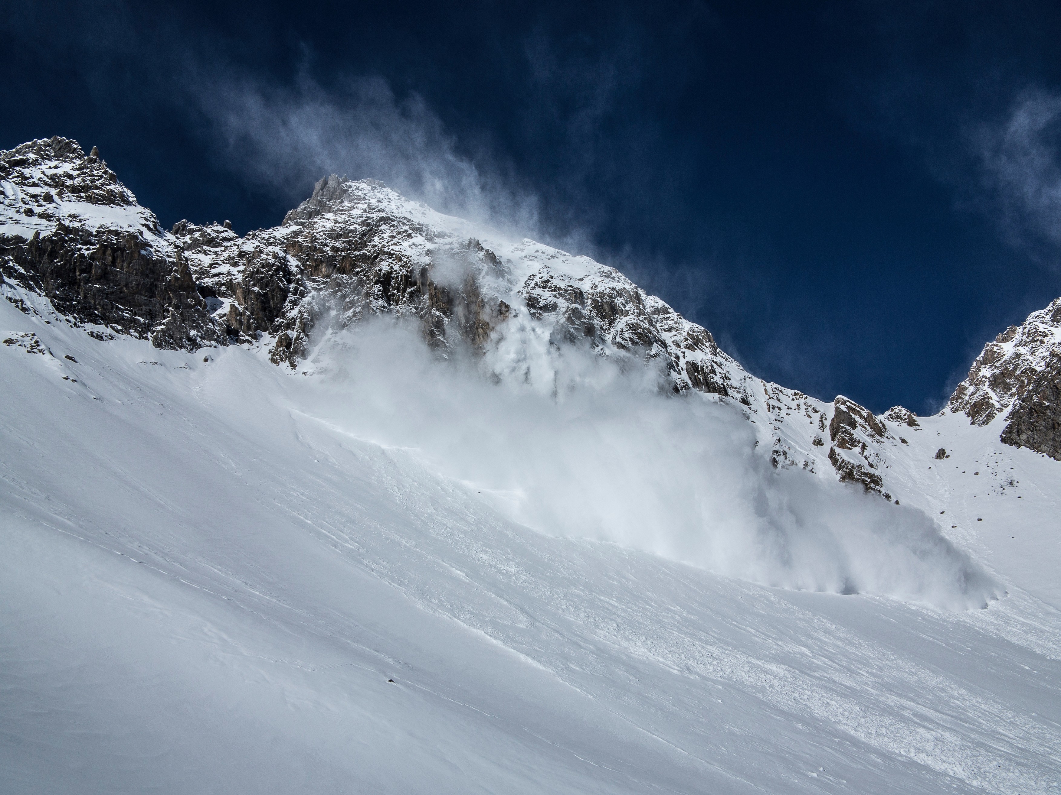 Avalanche cascading down snowy slope
