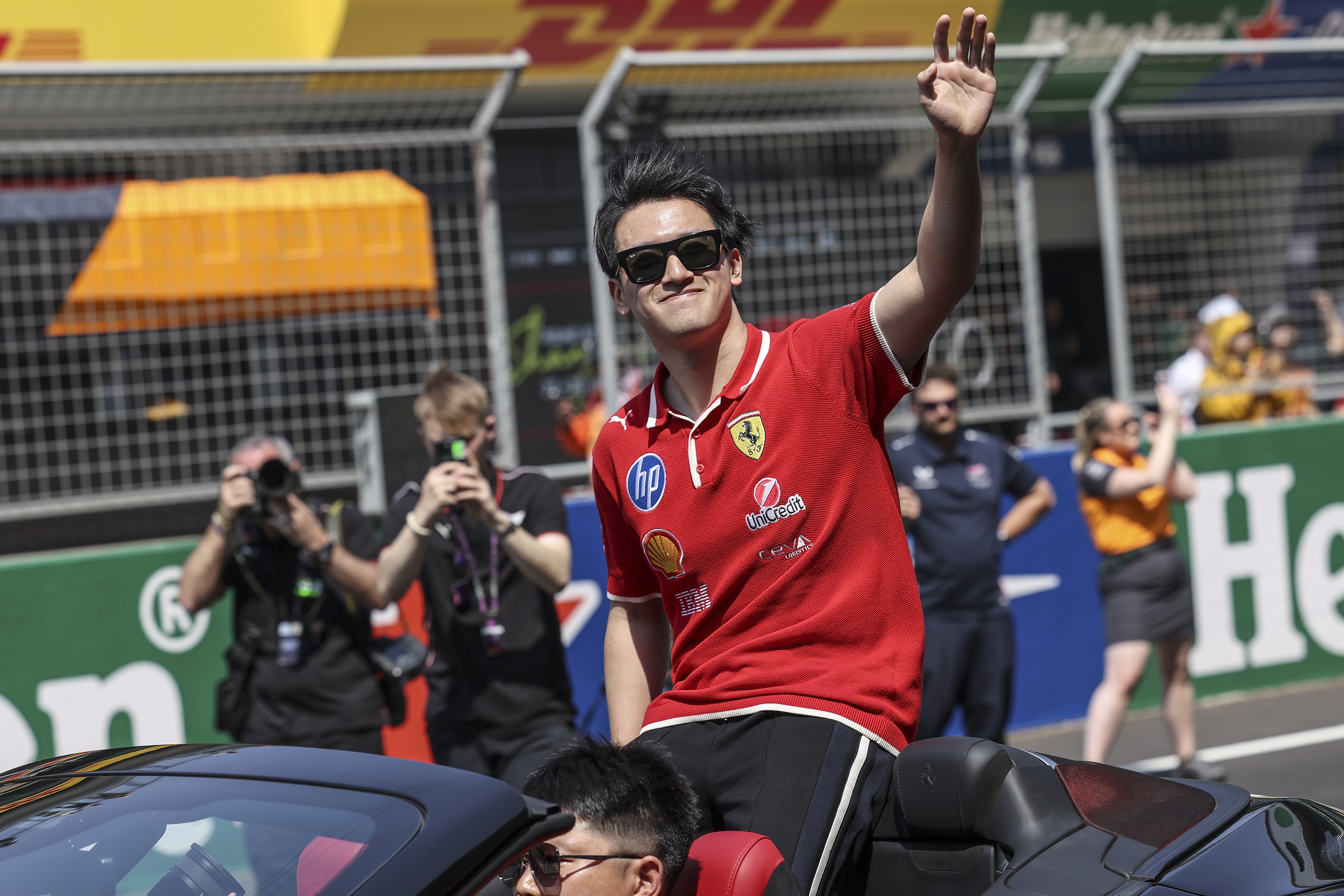 epa11982366 Ferrari reserve driver Zhou Guanyu of China waves hand to his fans during the driver parade before the 2025 Formula 1 Chinese Grand Prix at the Shanghai International Circuit in Shanghai, China, 23 March 2025.  EPA/WU HAO