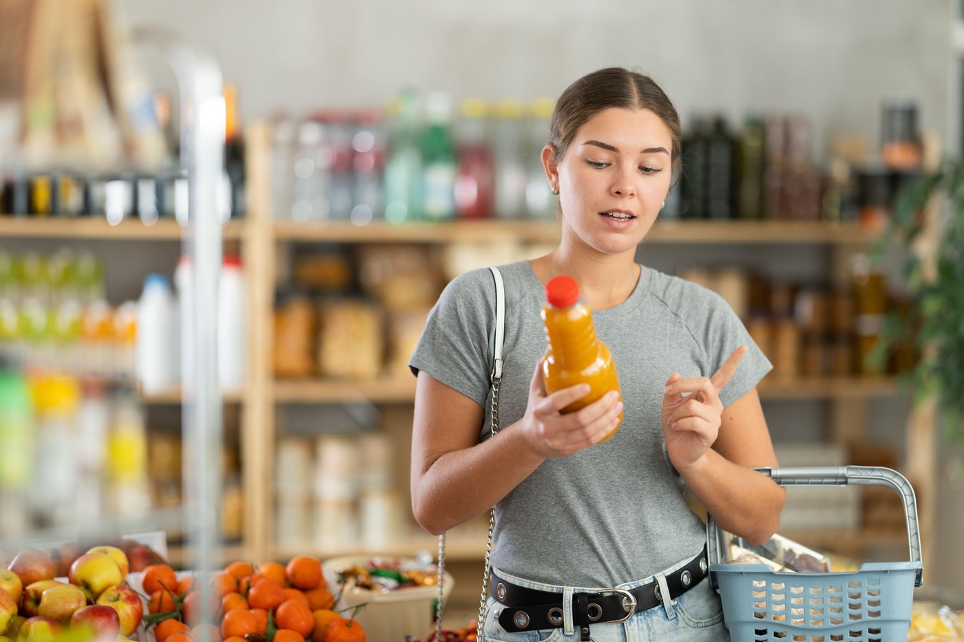 Young woman chooses natural peach juice in a supermarket. Customer holds glass bottle of peach juice with pulp in her hand,Image: 998858450, License: Royalty-free, Restrictions: , Model Release: no, Credit line: Iakov Filimonov / Alamy / Profimedia