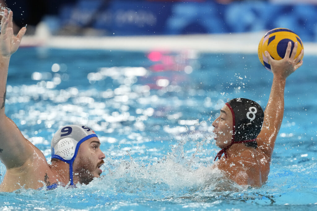 Japan's Mitsuru Takata, right, and Serbia's Nemanja Vico battle for the ball during the men's Water Polo Group B preliminary match between Serbia and Japan at the 2024 Summer Olympics, Sunday, July 28, 2024, in Saint-Denis, France. (AP Photo/Luca Bruno)