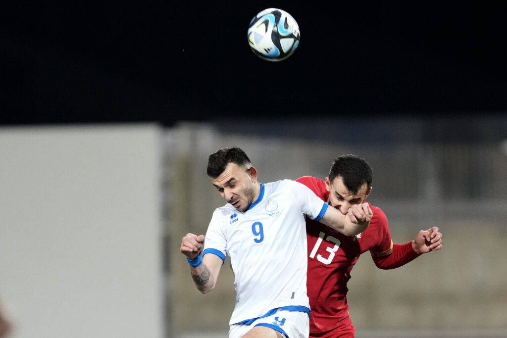 Serbias' Erhan Masovic, background, and Cyprus' Ioannis Pittas challenge for the ball during an international friendly soccer match between Cyprus and Serbia at AEK arena stadium in Larnaca, Cyprus, Monday, March 25, 2024. (AP Photo/Petros Karadjias)