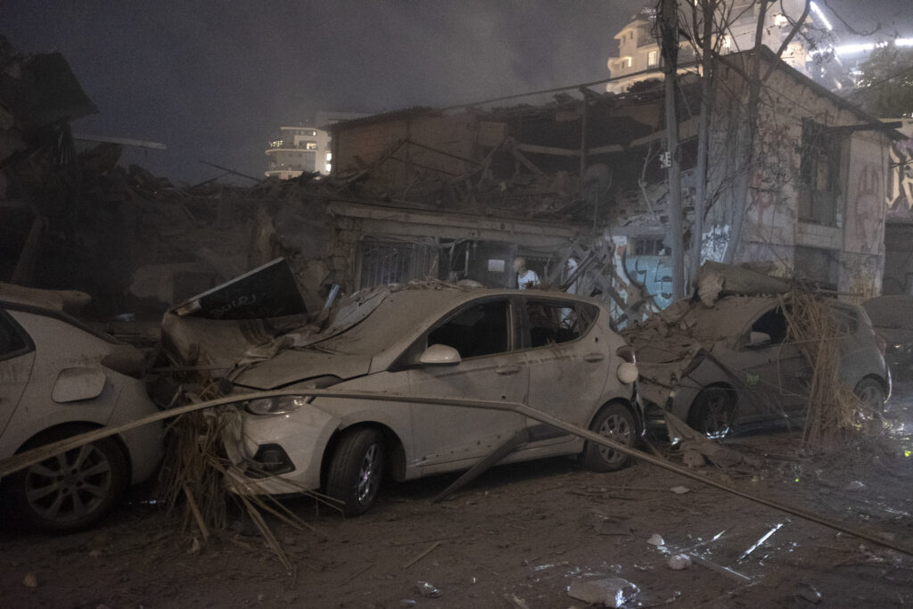 Cars and a building are seen after a m a rocket fired from the Gaza Strip in Tel Aviv, Israel, Saturday, Oct. 7, 2023. (AP Photo/Moti Milrod) ***ISRAEL OUT***