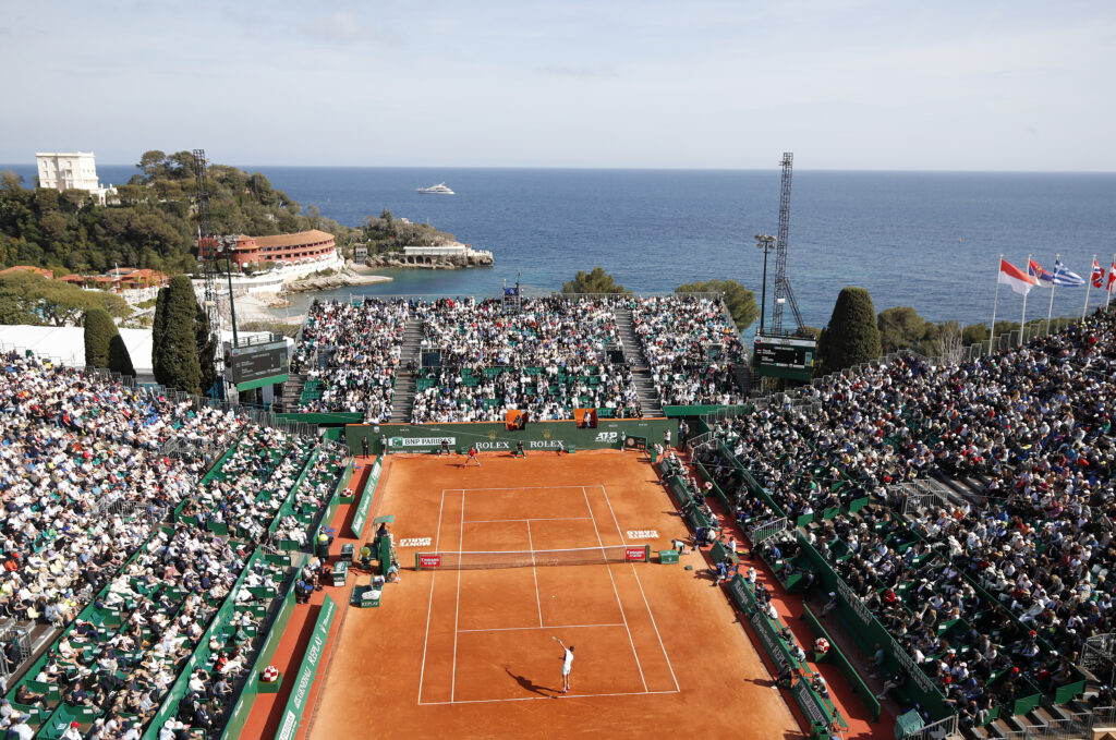epa10568453 Ivan Gakhov (bottom) serves the ball to Novak Djokovic of Serbia during their first round match at the Monte-Carlo Rolex Masters tournament in Roquebrune Cap Martin, France, 11 April 2023.  EPA-EFE/SEBASTIEN NOGIER