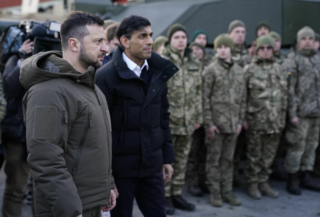 British Prime Minister Rishi Sunak and Ukrainian President Volodymyr Zelenskyy meet Ukrainian troops being trained to command Challenger 2 tanks at a military facility in Lulworth, Dorset, England, Wednesday Feb. 8, 2023. (Andrew Matthews/Pool via AP)
