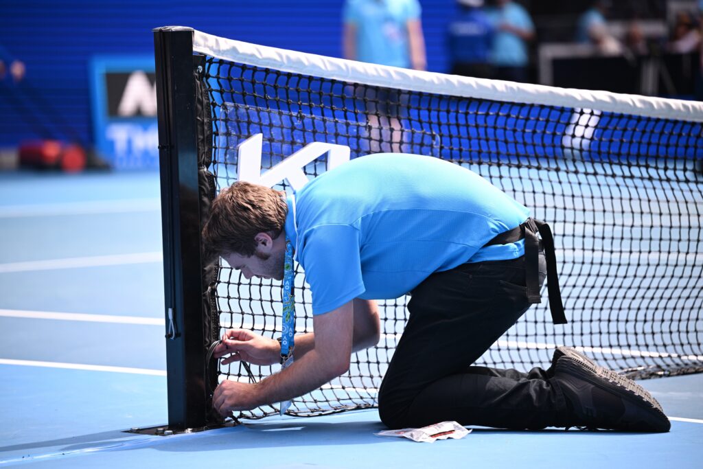 epa10419723 An attendant changes the net from doubles match to a singles match during the 2023 Australian Open tennis tournament at Melbourne Park in Melbourne, Australia 21 January 2023.  EPA-EFE/JAMES ROSS AUSTRALIA AND NEW ZEALAND OUT