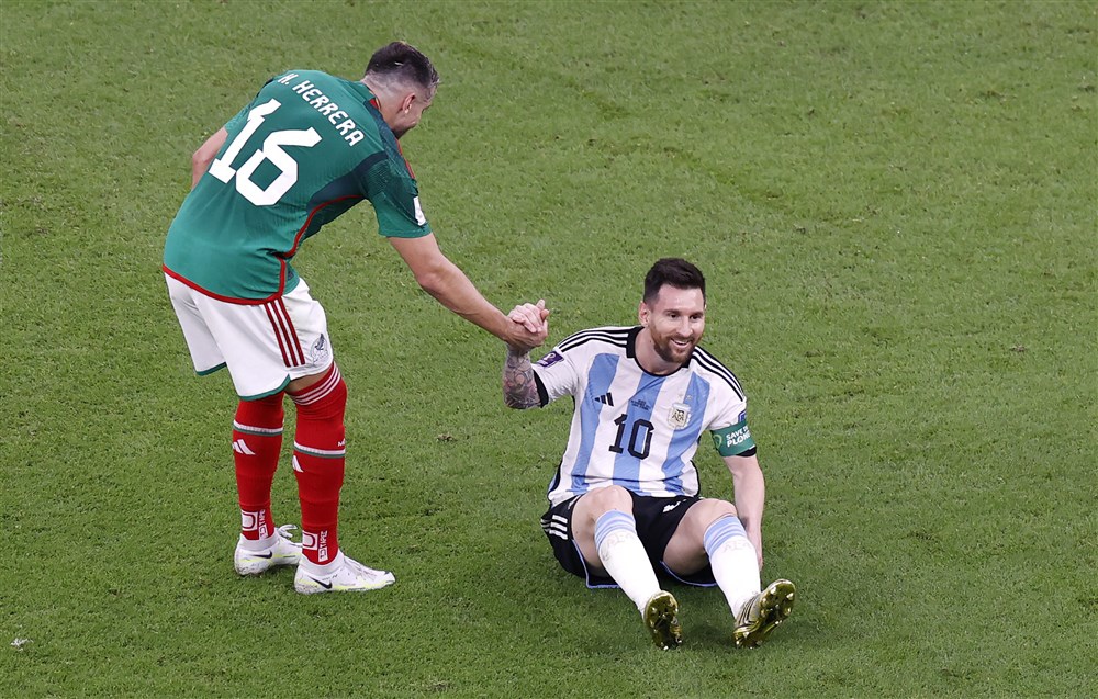 epa10331088 Hector Herrera (L) of Mexico helps Lionel Messi of Argentina back up on his feet during the FIFA World Cup 2022 group C soccer match between Argentina and Mexico at Lusail Stadium in Lusail, Qatar, 26 November 2022.  EPA-EFE/Rungroj Yongrit