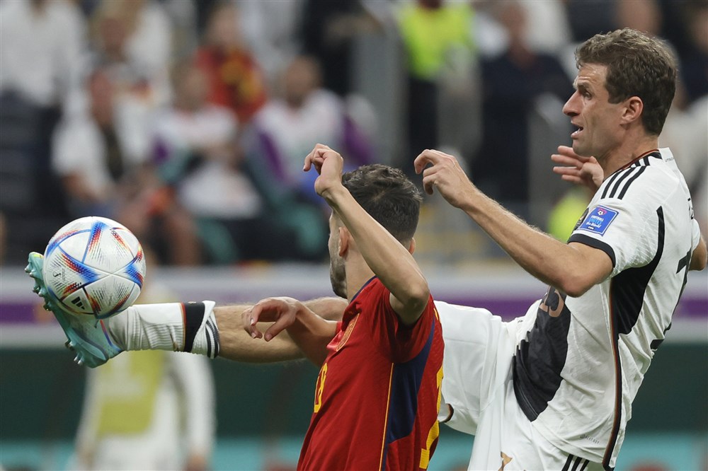 epa10333330 Jordi Alba (L) of Spain in action against Thomas Mueller of Germany during the FIFA World Cup 2022 group E soccer match between Spain and Germany at Al Bayt Stadium in Al Khor, Qatar, 27 November 2022.  EPA-EFE/Ronald Wittek