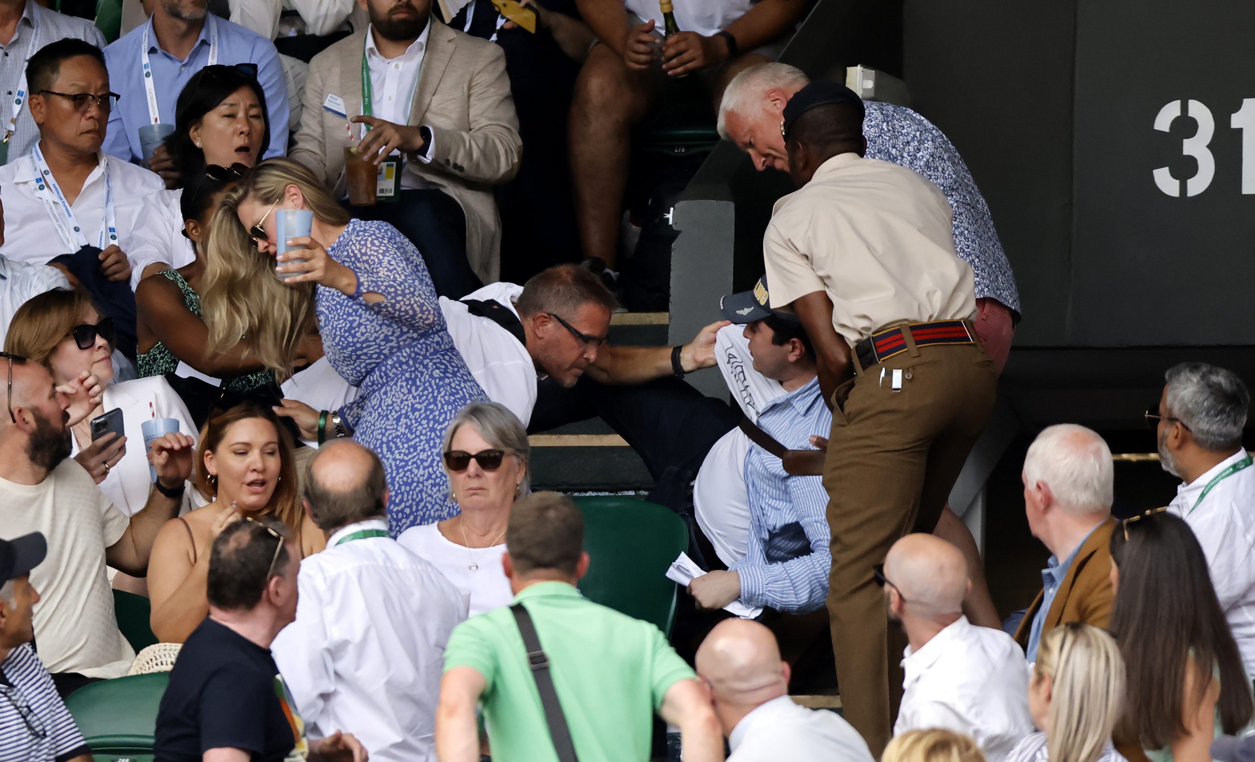 epa10063948 Security remove a man fom the stands during the men's final match between Novak Djokovic of Serbia and Nick Kyrgios of Australia at the Wimbledon Championships, in Wimbledon, Britain, 10 July 2022.  EPA-EFE/TOLGA AKMEN   EDITORIAL USE ONLY