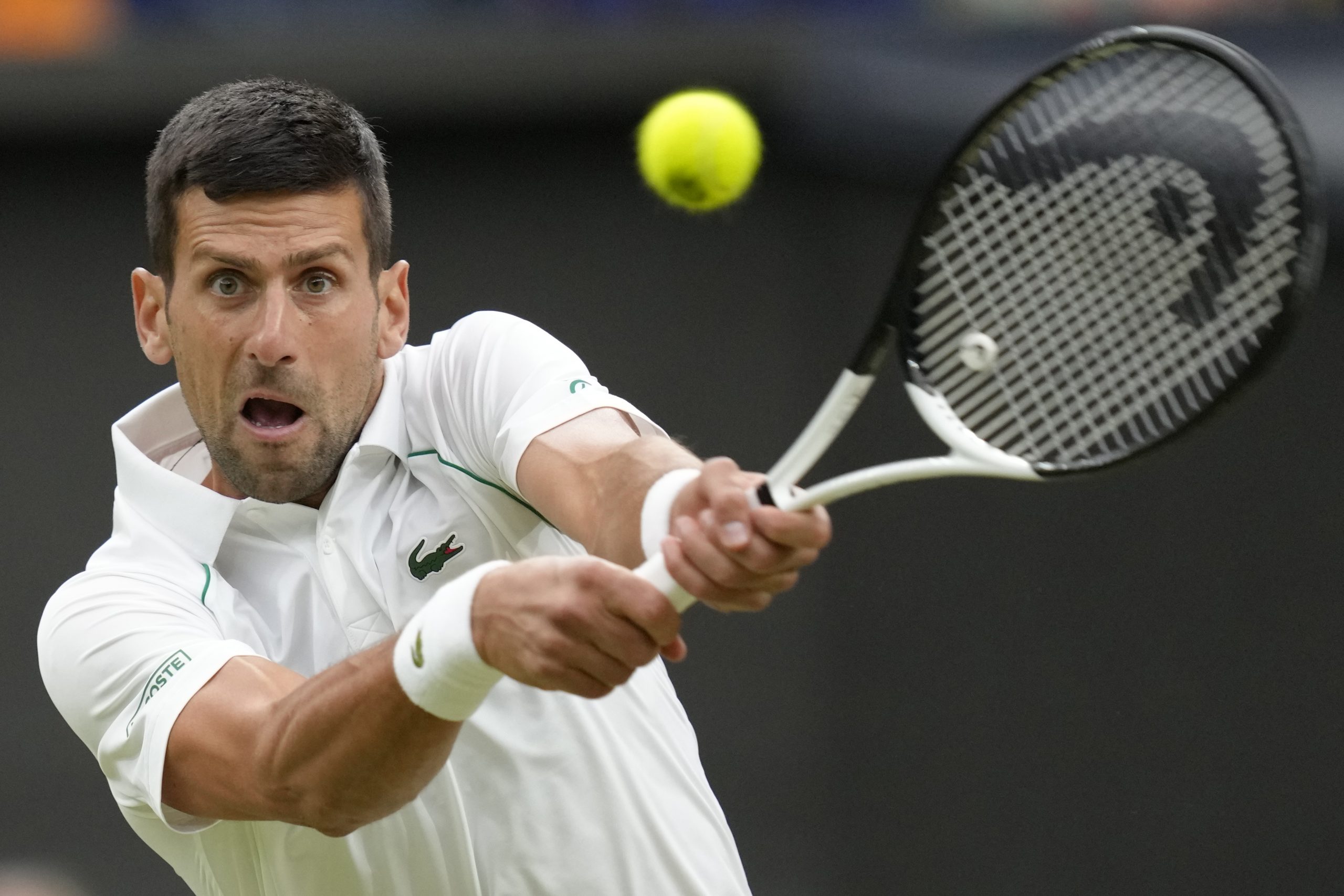Serbia's Novak Djokovic returns the ball to Tim van Rijthoven of the Netherlands during a men's fourth round singles match on day seven of the Wimbledon tennis championships in London, Sunday, July 3, 2022.(AP Photo/Kirsty Wigglesworth)