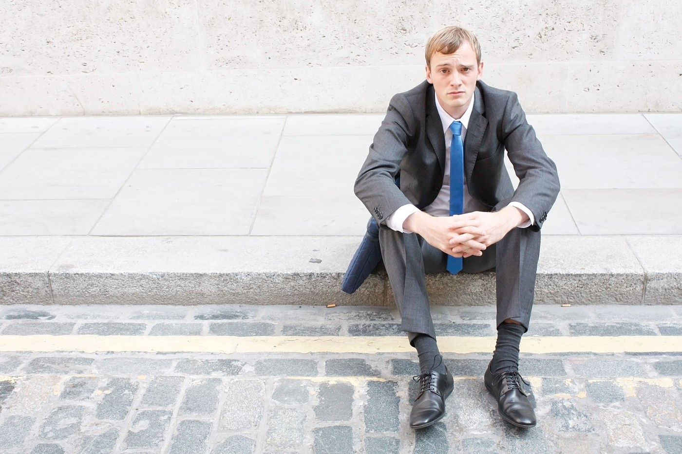 A worried business man sitting on some stairs