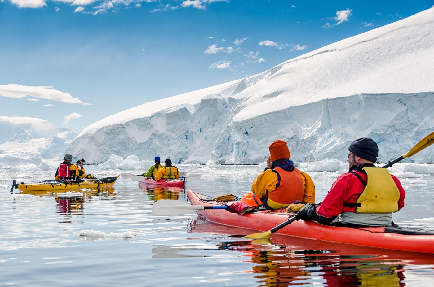 Kayaking At Neko Harbour Antarctica // NEKO HARBOUR, Antarctica — Kayakers glide through calm waters at Neko Harbour, Antarctica, pausing to admire the breathtaking scenery of glaciers, icebergs, and snow-covered mountains. This serene scene captures the
