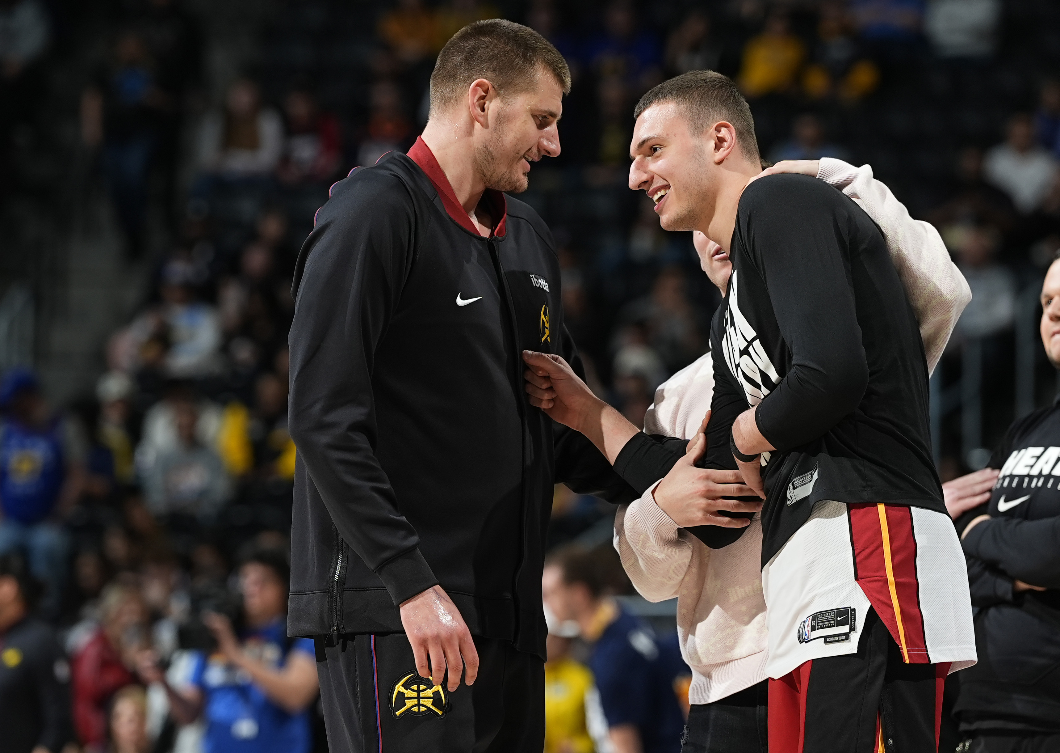 Denver Nuggets center Nikola Jokic, left, greets Miami Heat forward Nikola Jovic before an NBA basketball game Thursday,, Feb. 29, 2024, in Denver. (AP Photo/David Zalubowski)