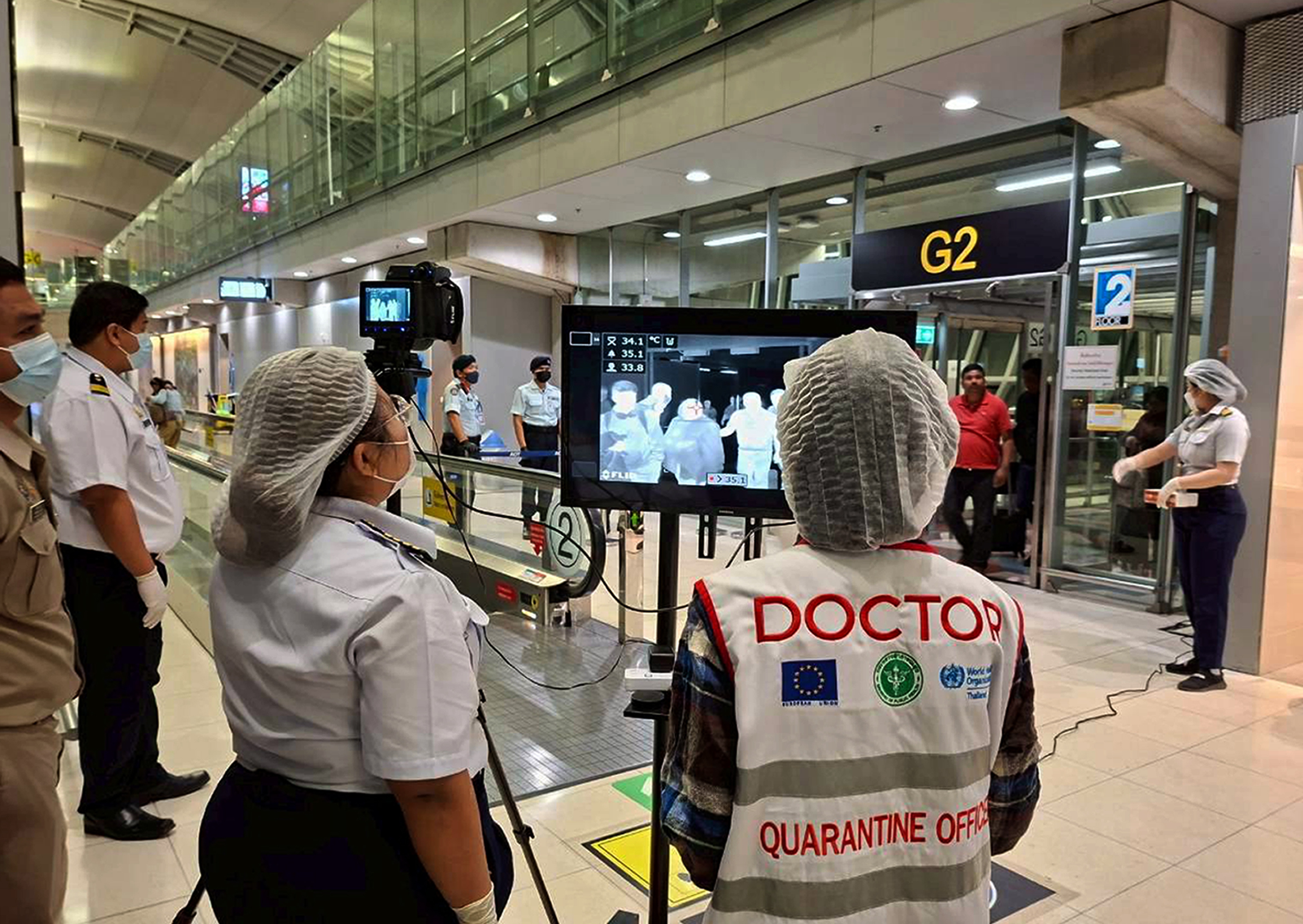 epa12680327 A handout photo released by Suvarnabhumi Airport shows Thai health officials wearing protective masks