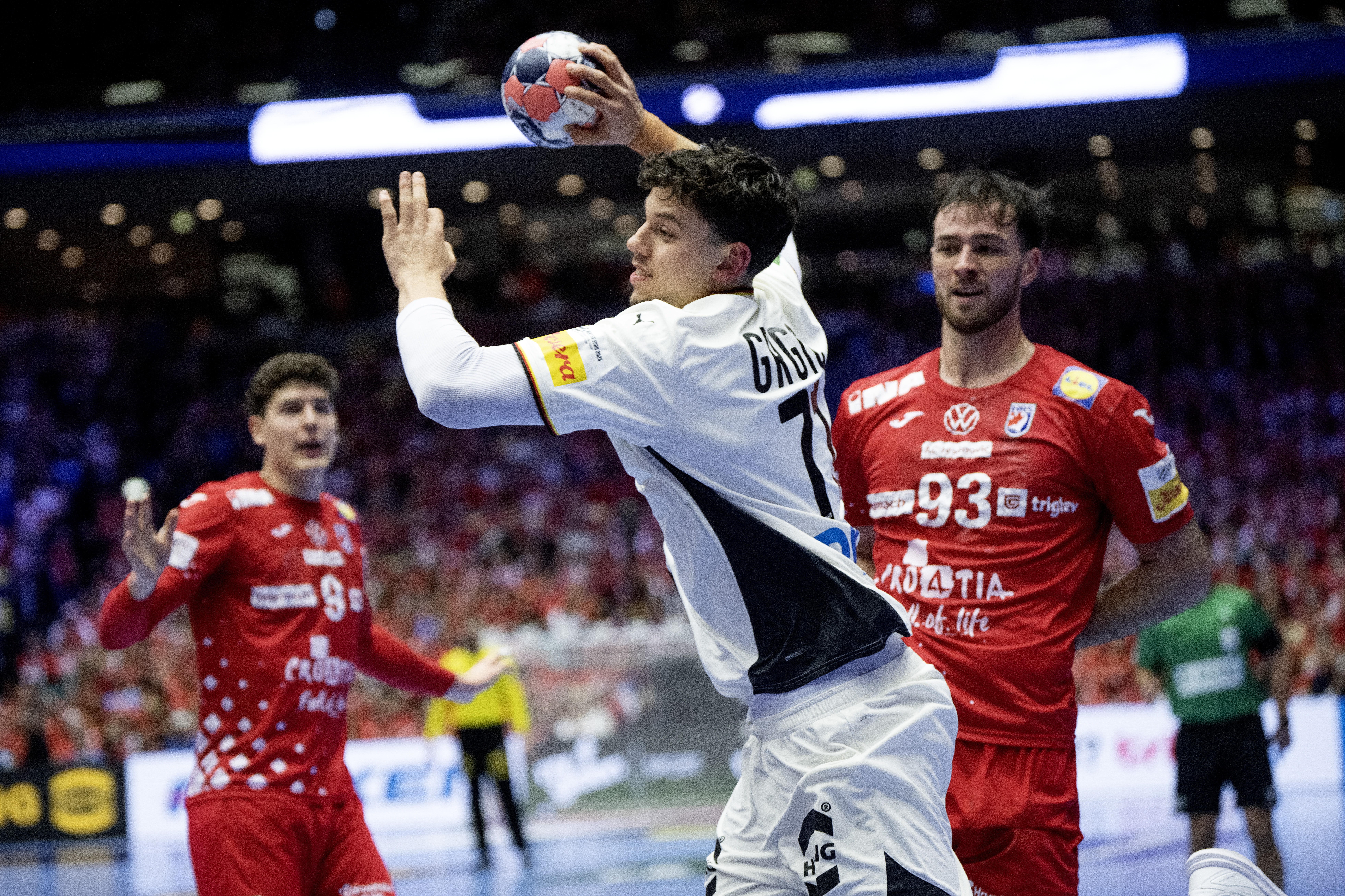 Marko Grgic (C) in action with Croatia's Veron Nacinovic (R) during the EHF Euro 2026