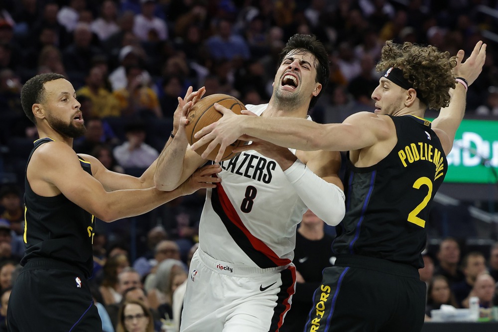 epa12541231 Portland Trail Blazers forward Deni Avdija (C) draws a fo