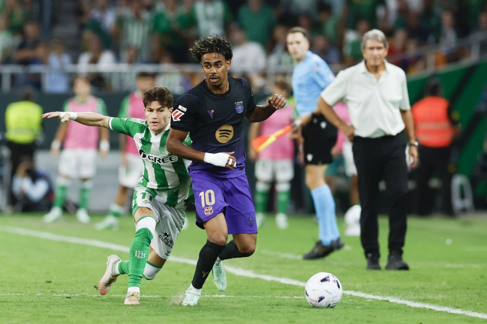 epa13312061 FC Barcelona's Lamine Yamal (C) in action against Betis's Fran Garcia
