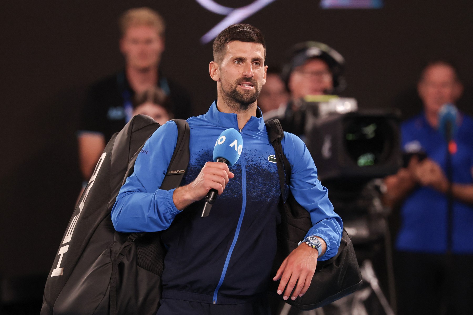 Serbia's Novak Djokovic speaks into the microphone on court after winning h