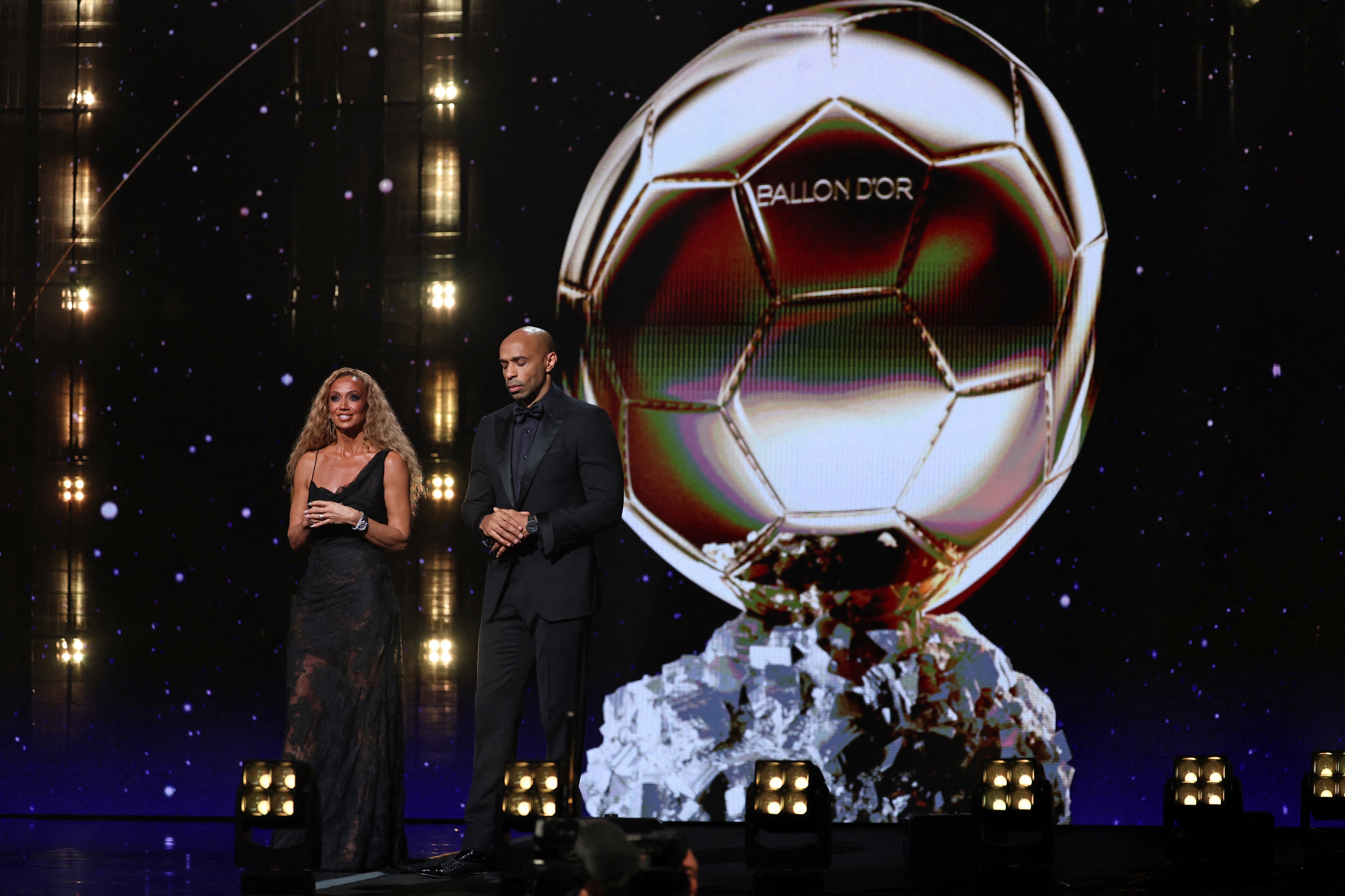 Hosts Kate Scott and Thierry Henry on stage during the 2026 Ballon d'Or France Football award ceremony at the Palladium Theatre in London on October 26, 2026.