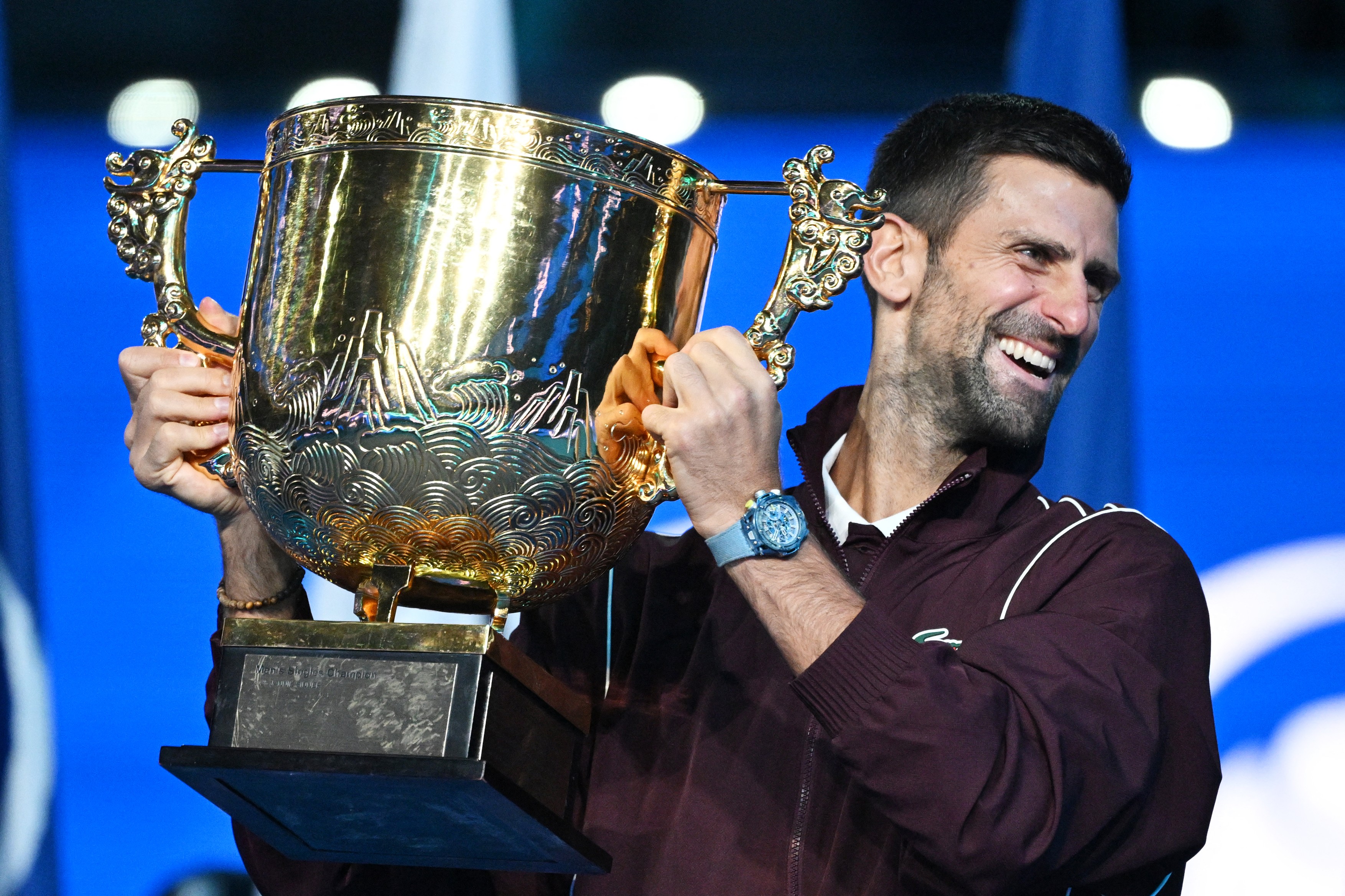 Serbia’s Novak Djokovic holds up the trophy as he celebrates winning the men’s singles final against Australia’s Alex de Minaur at the China Open