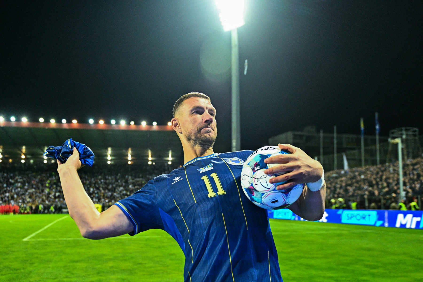 Bosnia-Herzegovina's forward #11 Edin Dzeko throws a jersey to supporters a