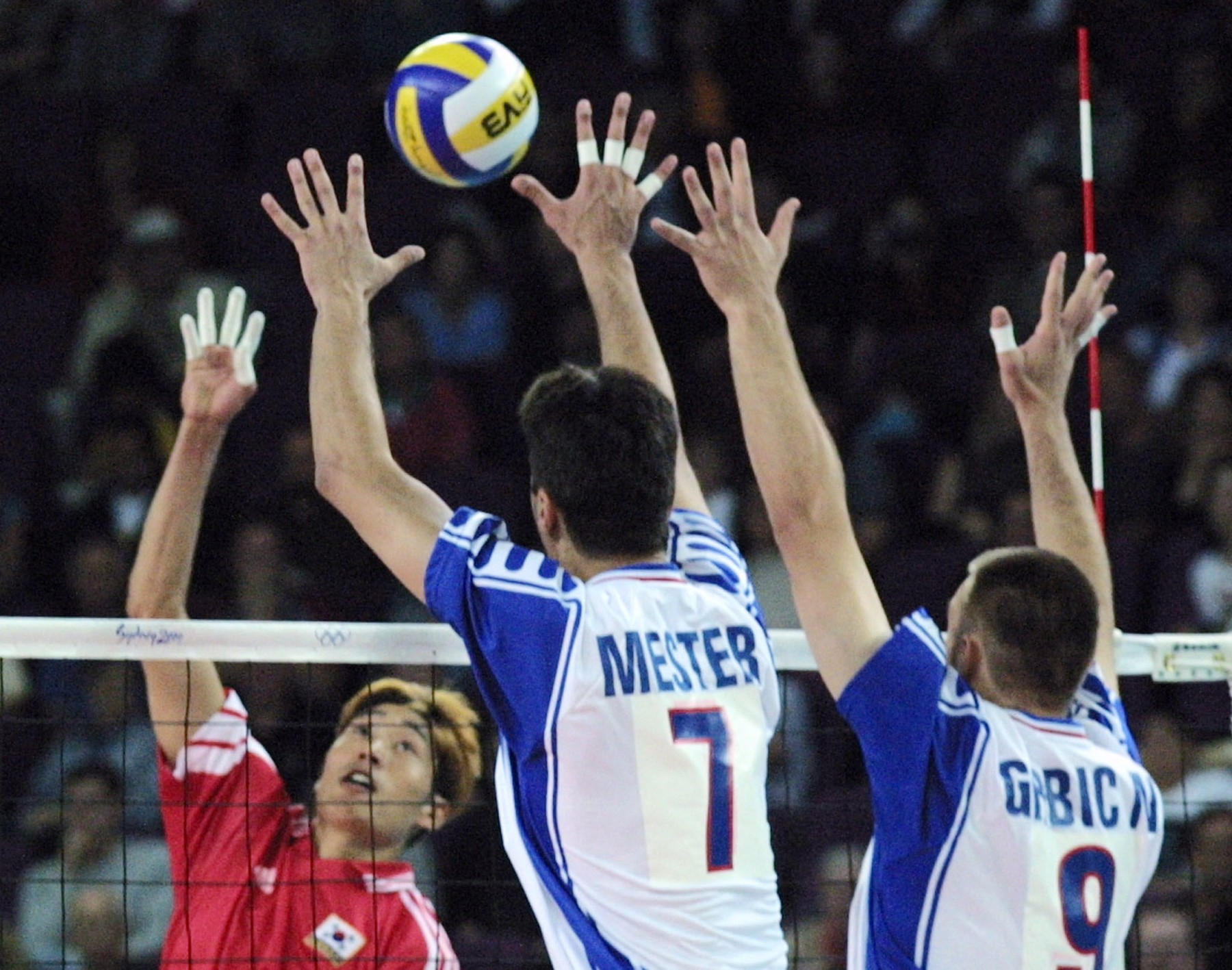 Korean Shin Jin-Sik (L) tries to smash over Yugoslavia's Djula Mester (C) and Nikola Grbic