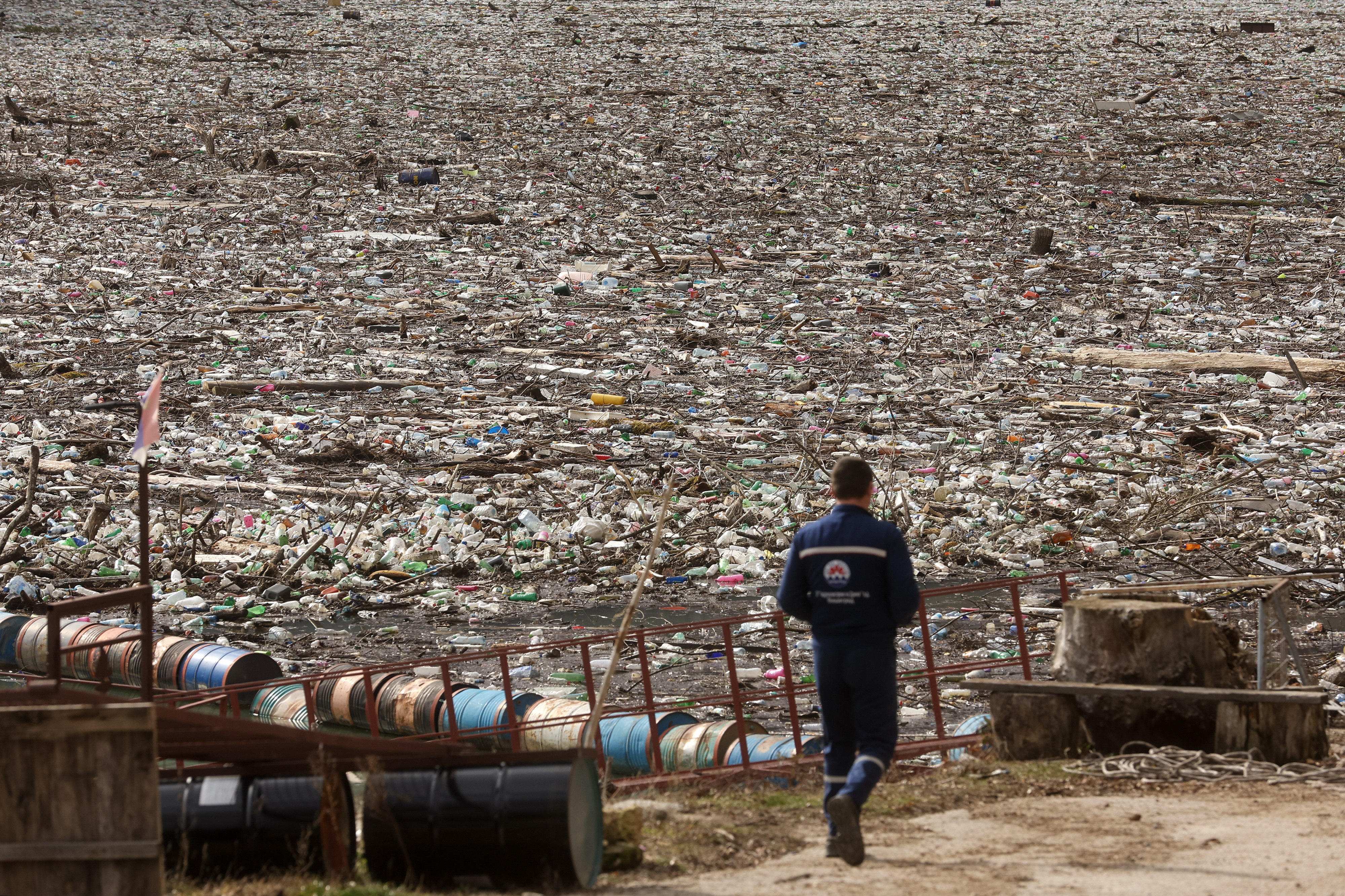 A worker toward the waste floating on the Drina river in Visegrad, Bosnia, Thursday, Feb. 5, 2026. (AP Photo/Armin Durgut)