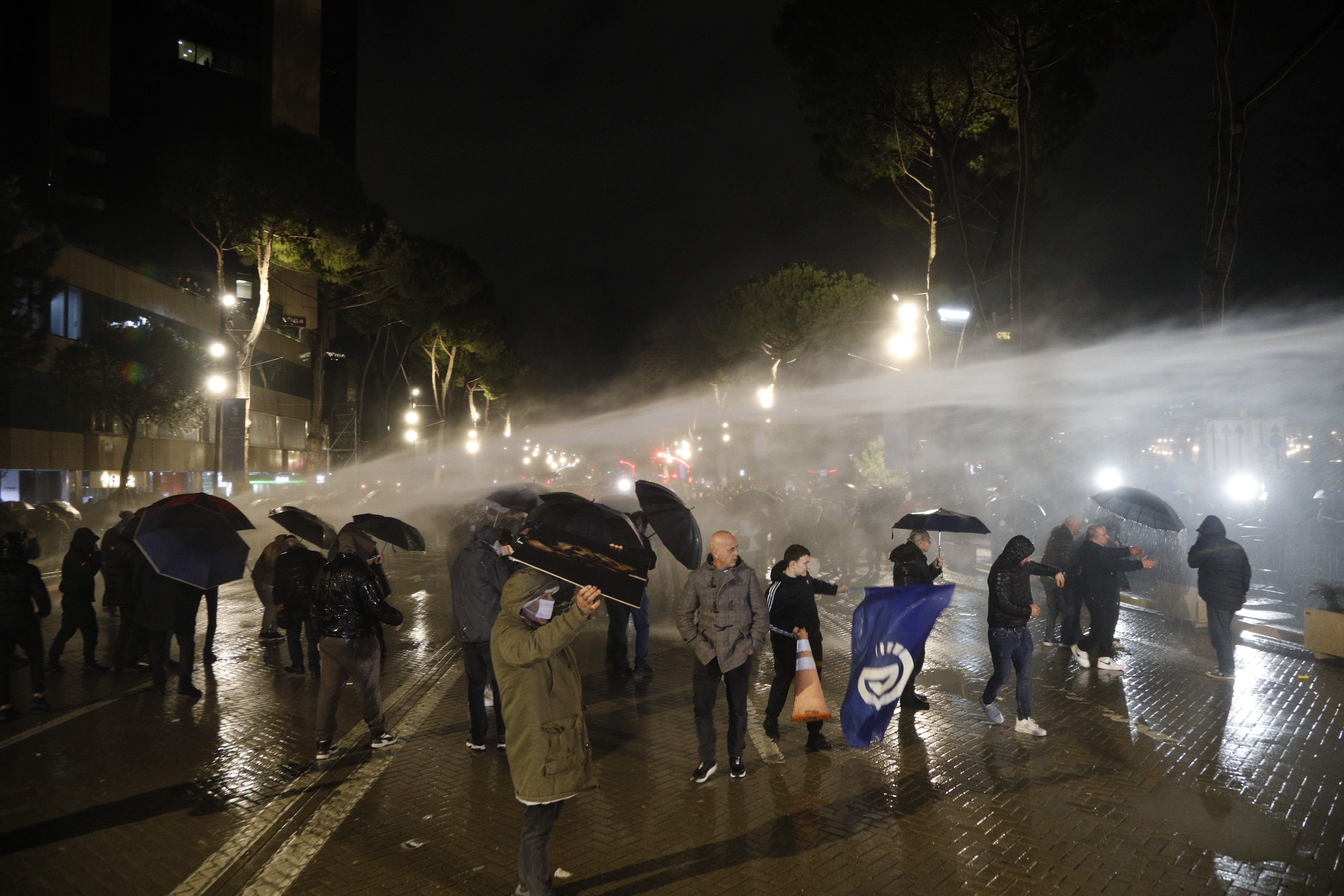 epa12725111 Opposition supporters use umbrellas to protect themselves from a water ca
